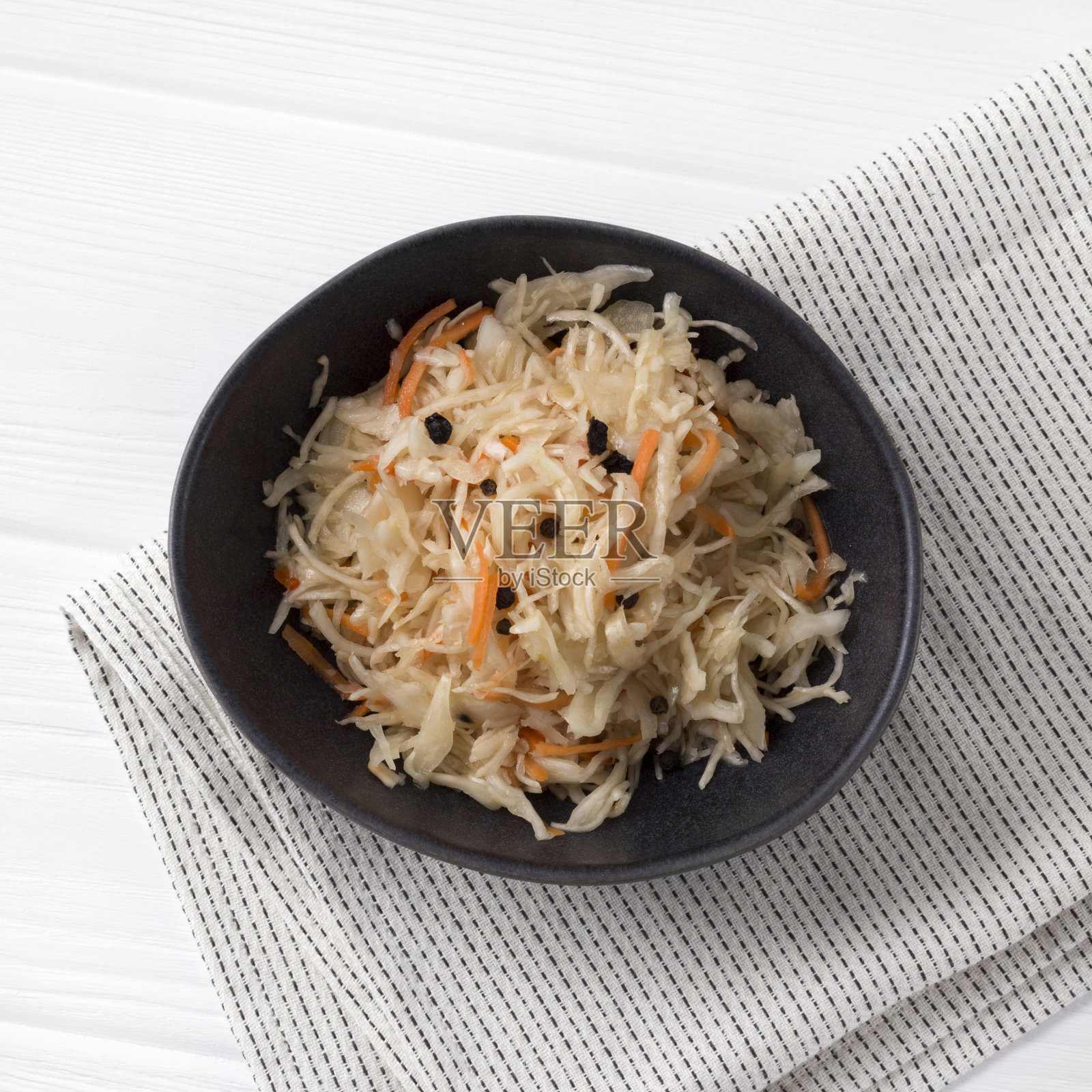 发酵的卷心菜。传统的俄罗斯开胃菜泡菜和胡萝卜在工艺盘在白色木桌。照片摄影图片