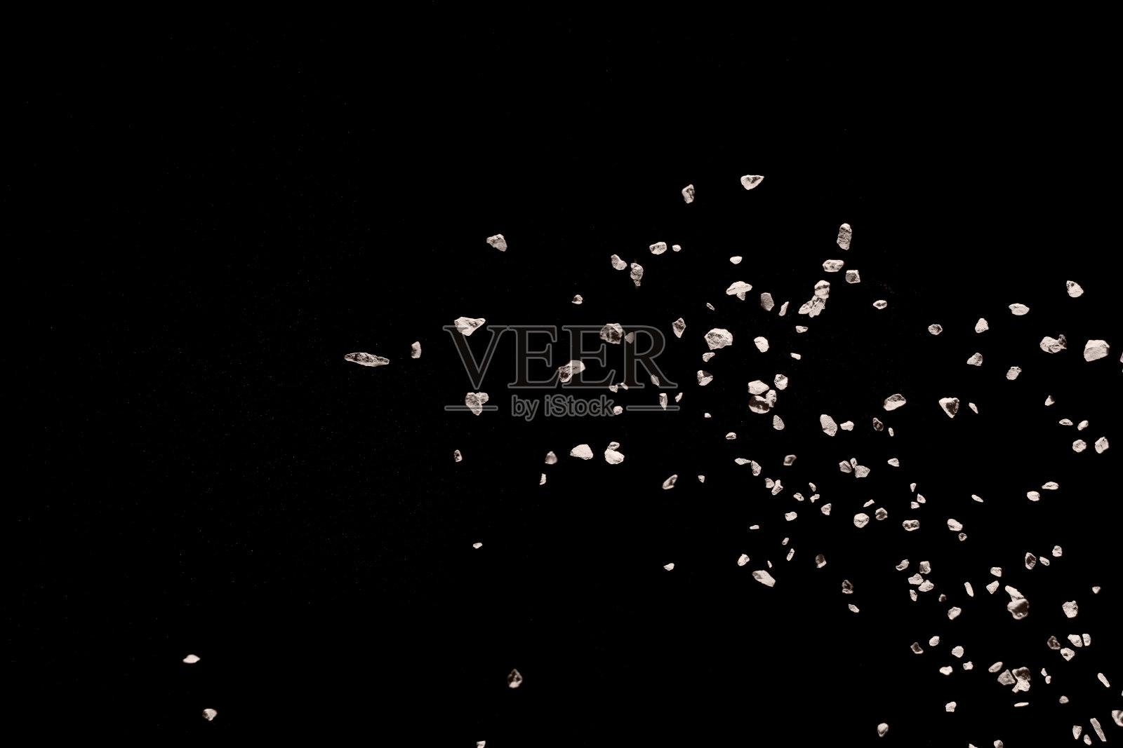 碎裂的石头碎片在黑色背景下爆炸。照片摄影图片