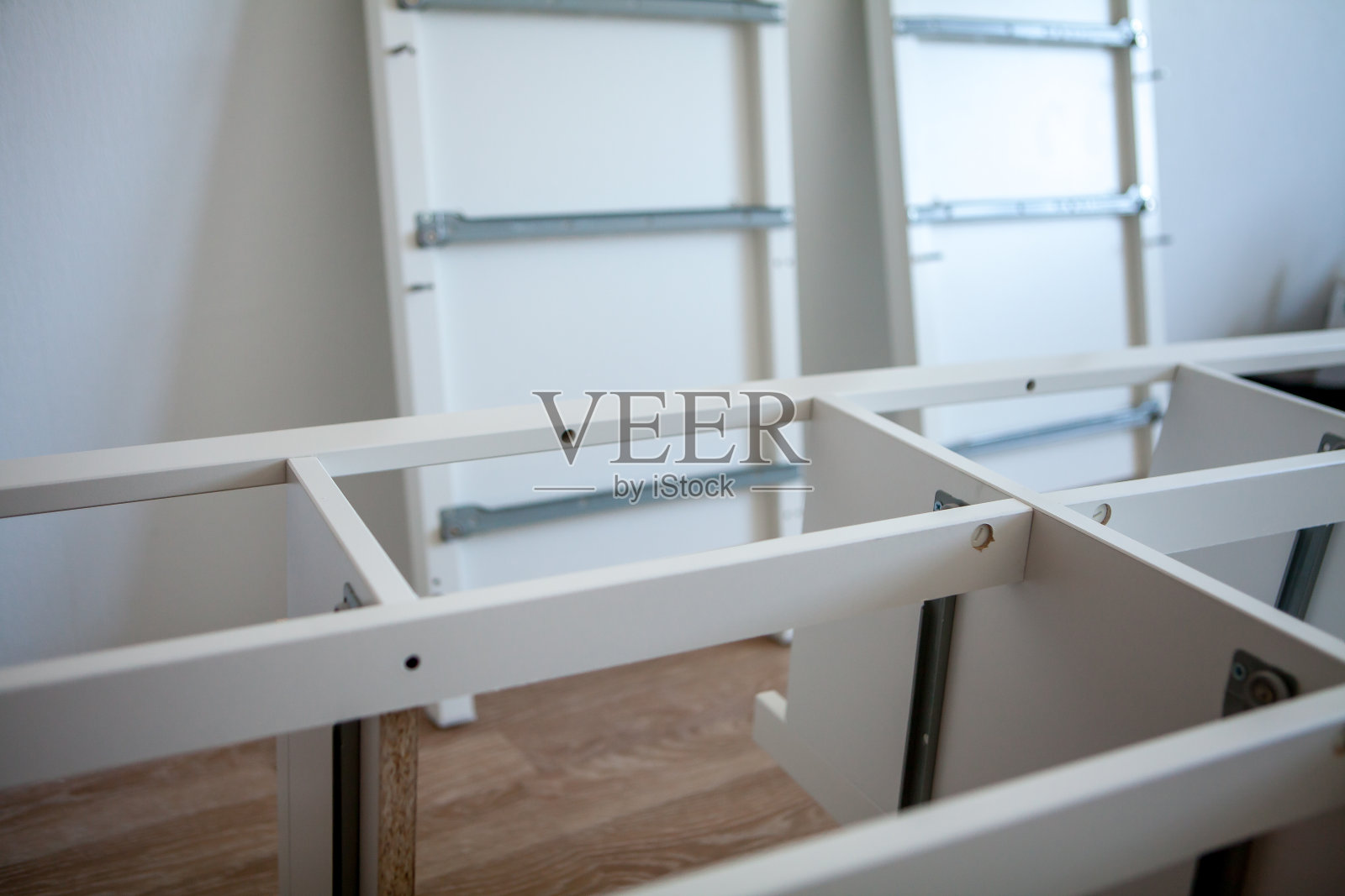 用螺丝刀组装的家具。白色的家具。有抽屉的柜子照片摄影图片