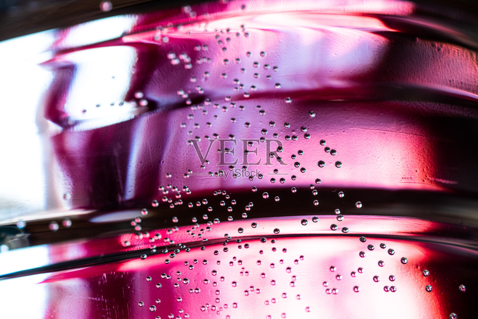 粉红色背景的小气泡悬浮在水中照片摄影图片