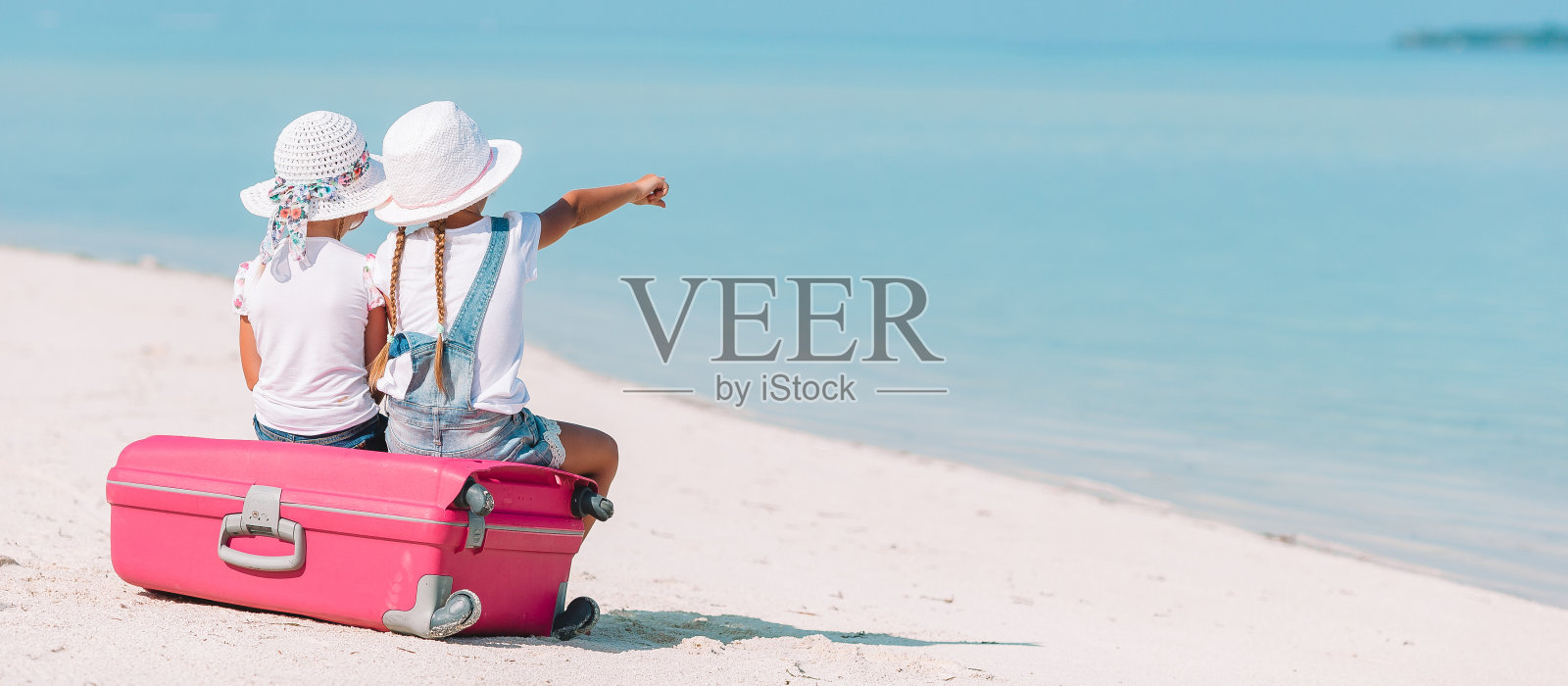 带着大行李箱的小女孩和热带海滩的地图照片摄影图片