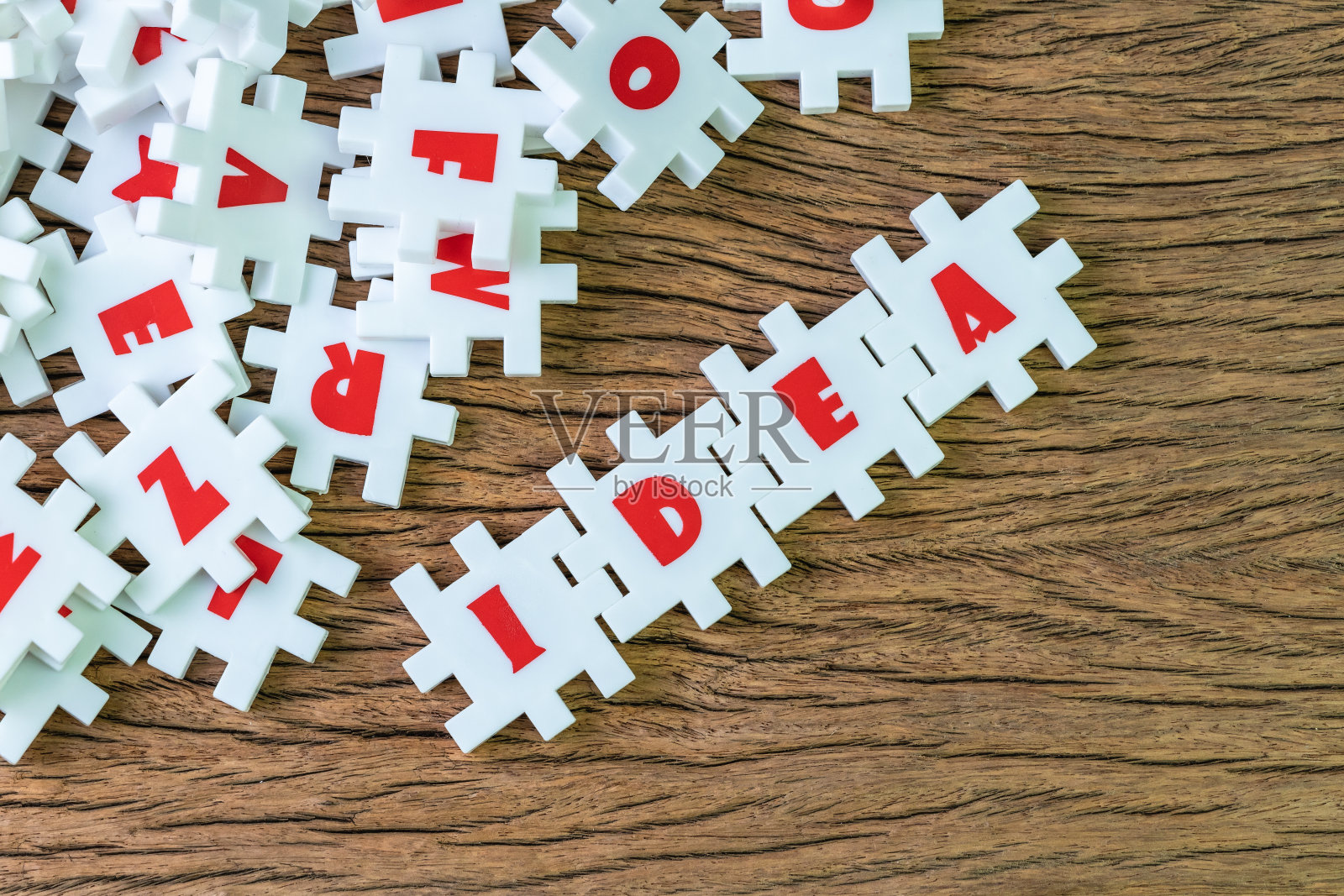 商业想法，创造力或灵感在工作和解决问题，丰富的白色拼图与字母结合单词idea周围的其他字母在木制桌子的背景照片摄影图片