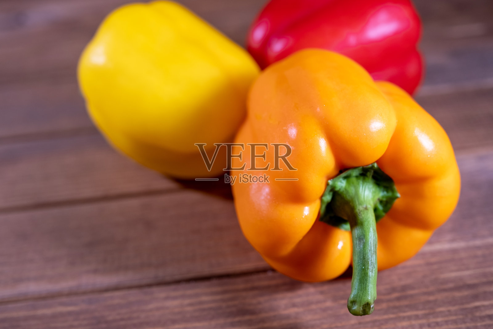 深色木桌上放着五颜六色的新鲜辣椒照片摄影图片