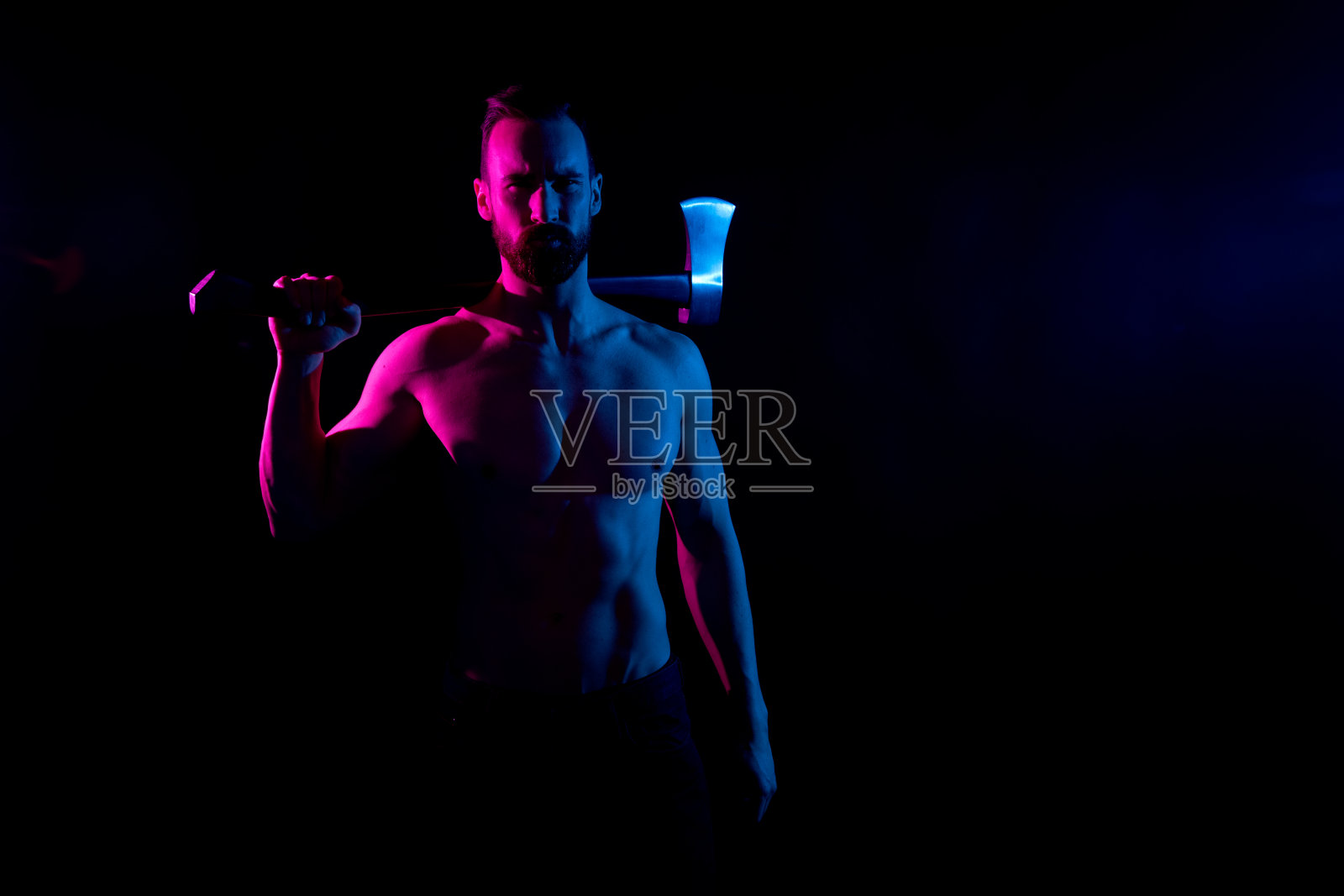 性感的赤膊男人在内衣和拿着一把斧头照片摄影图片