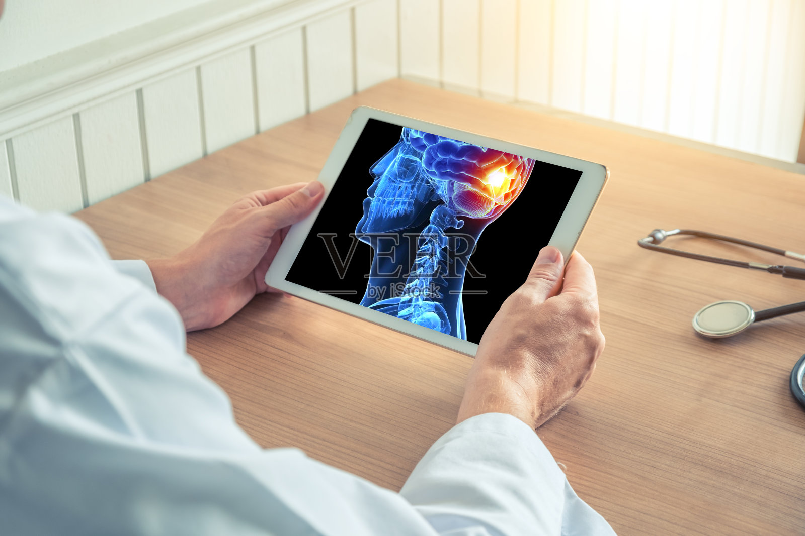 医生拿着一个数字平板，上面有3D颅骨的x光片，大脑后部有疼痛感。头痛偏头痛或创伤概念照片摄影图片