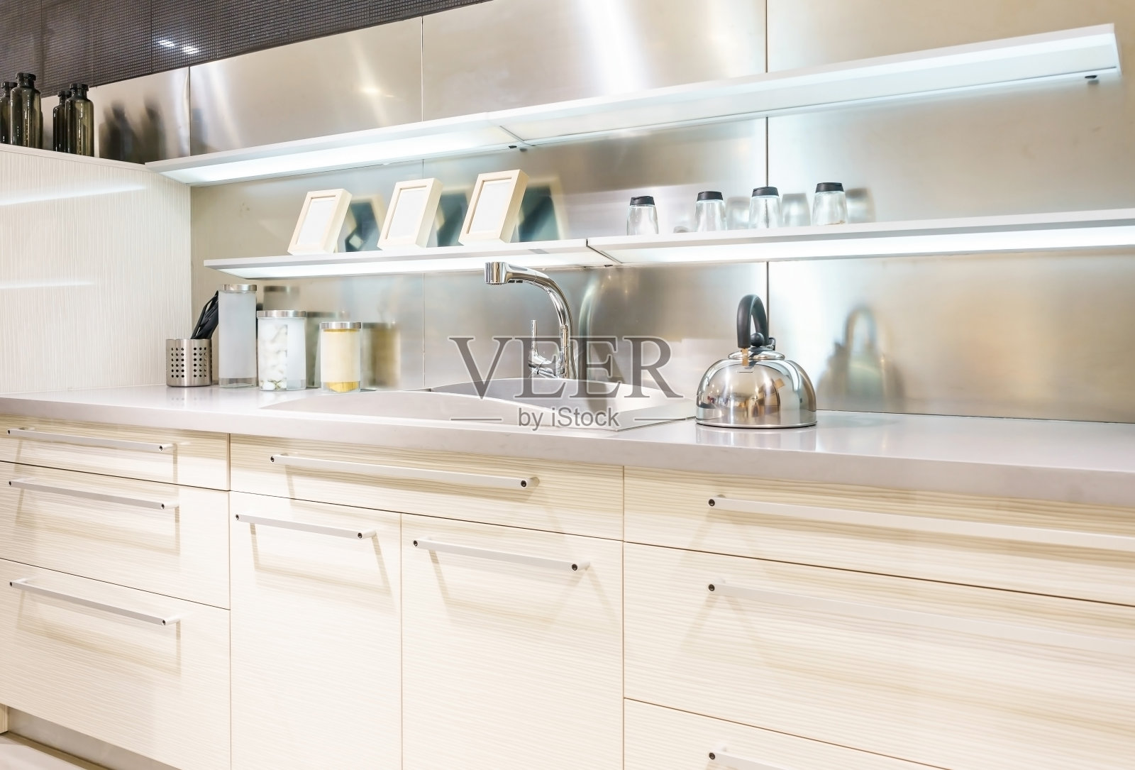 不锈钢厨房水槽和自来水在厨房。公寓厨房的内部。内置的电器。厨房电器。家用电器照片摄影图片