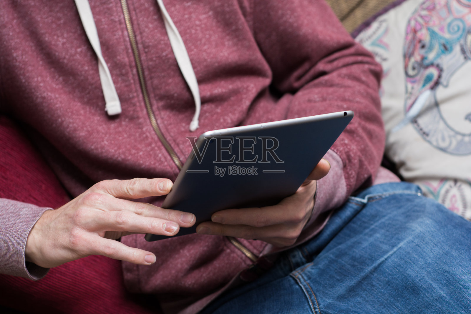 穿着帽衫的学生用触屏平板电脑照片摄影图片