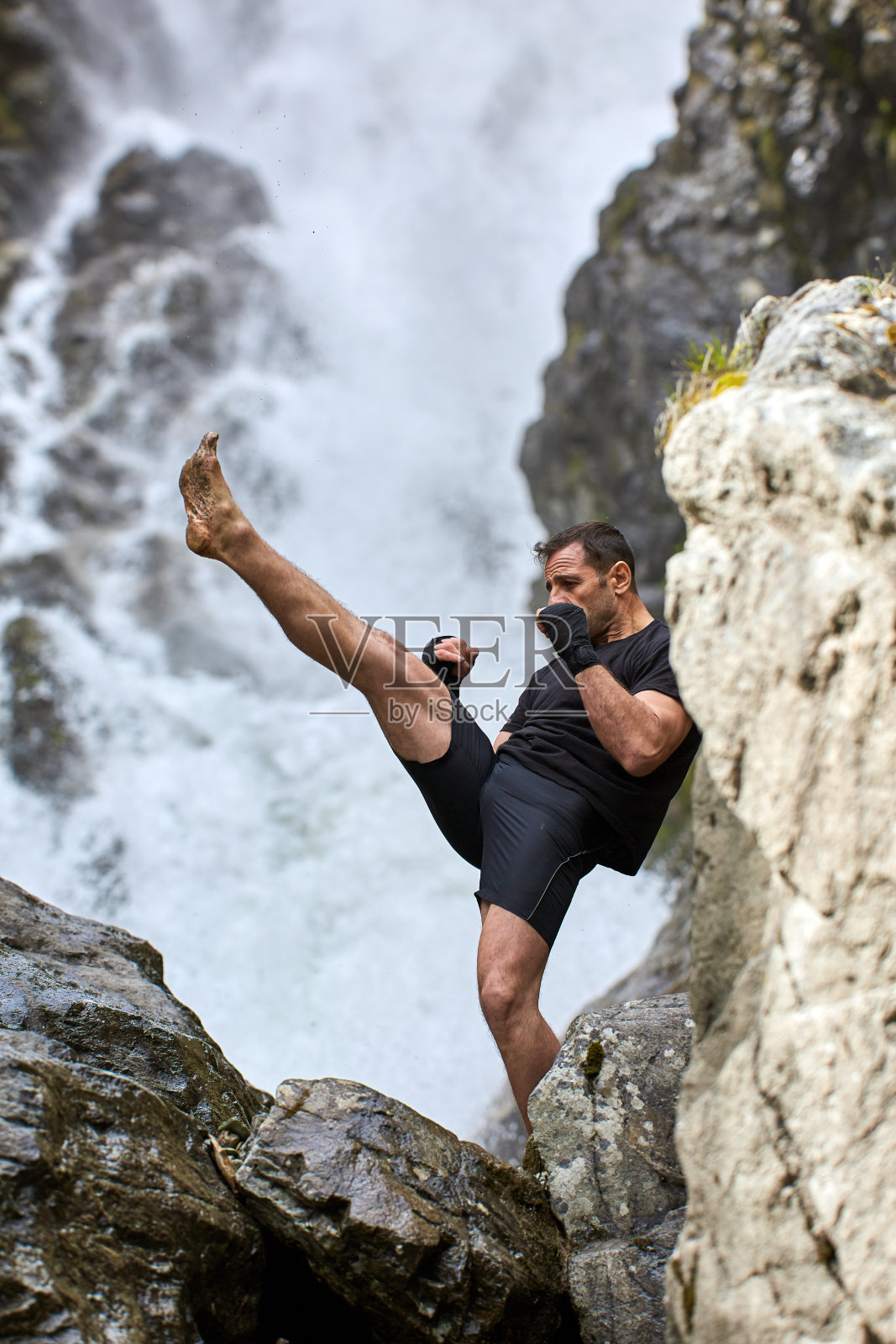 在瀑布边训练泰拳拳手照片摄影图片