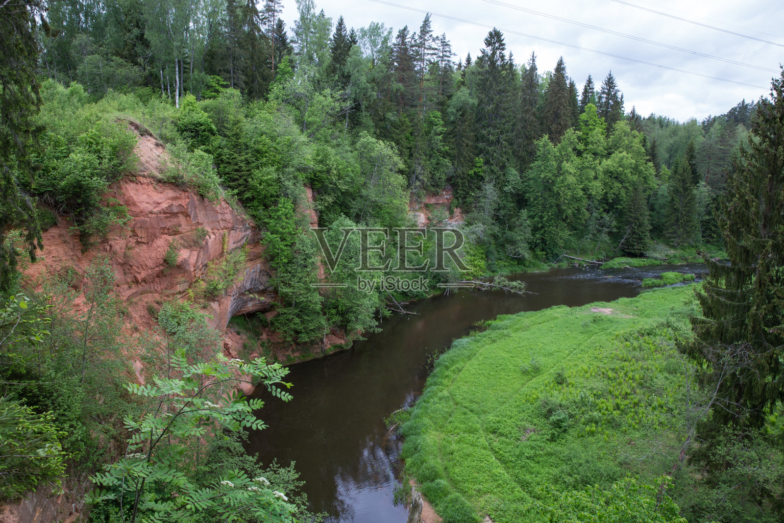 斯特劳普市，拉脱维亚共和国。红色的岩石和布拉斯河。绿色和杂草丛生的森林。6月1。2019年旅游的照片。照片摄影图片