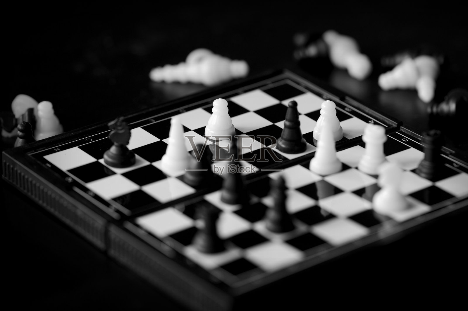 旅行象棋在一个黑暗的背景近景。黑色和白色照片摄影图片