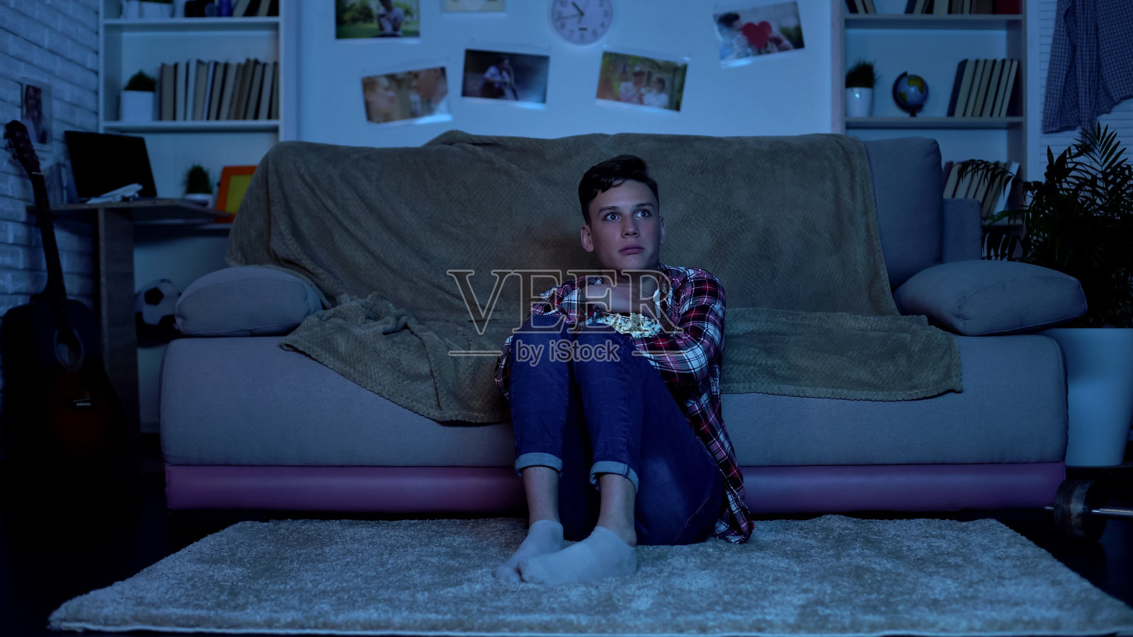 青少年深夜在家看恐怖电影，吃爆米花，情绪低落照片摄影图片