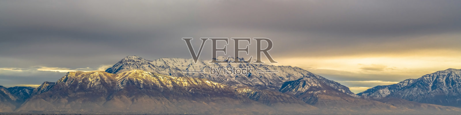 壮丽的山峰被白雪覆盖，被阳光照亮的全景照片摄影图片