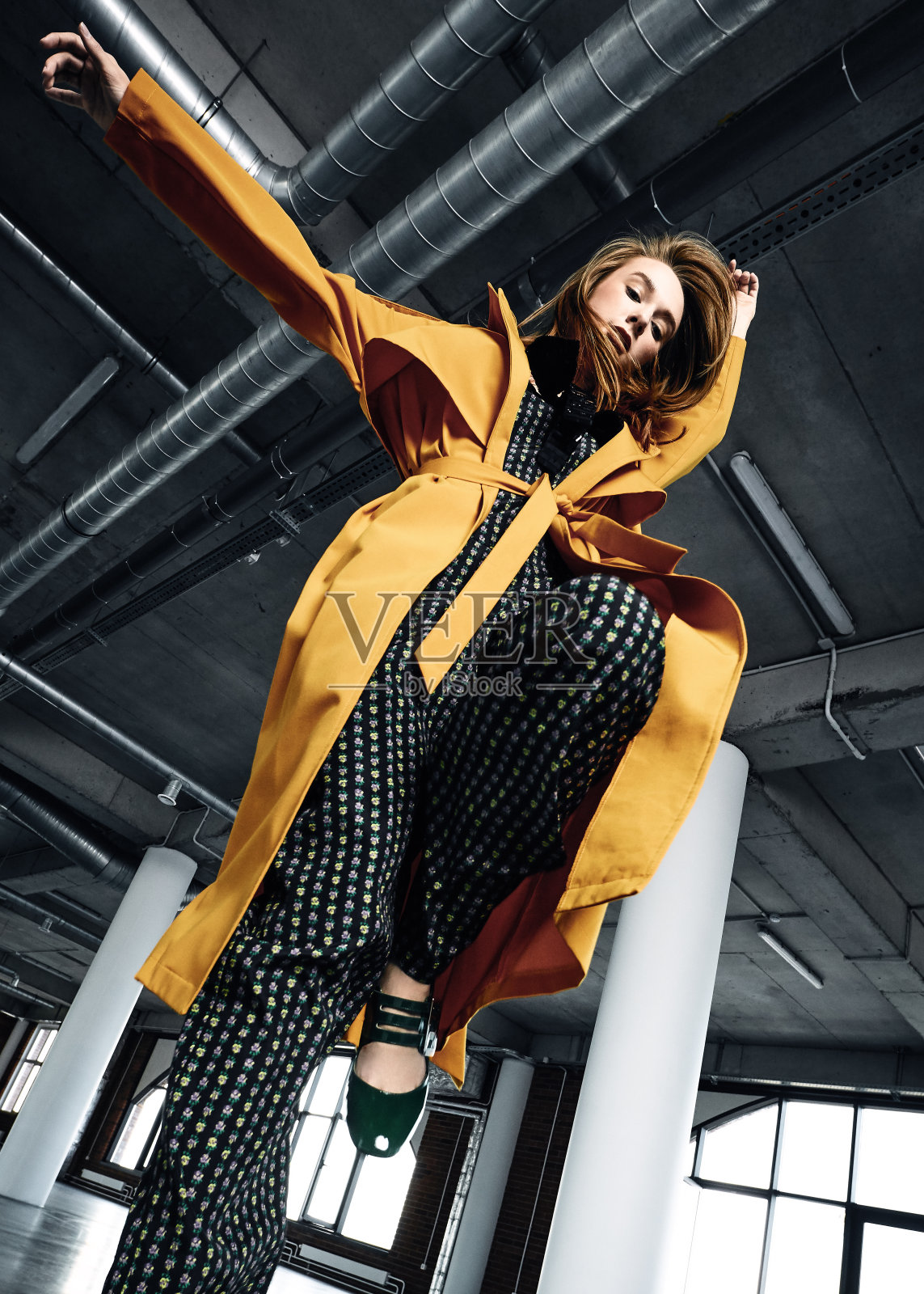 穿黄大衣的年轻女子照片摄影图片