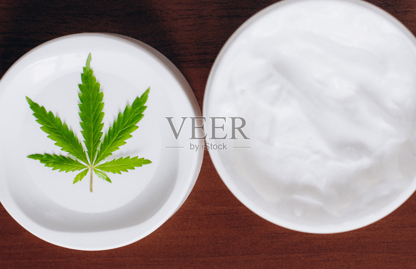 瓶大麻白色洗液。详细的大麻霜与大麻叶-大麻主题概念。从生物和生态植物中提取大麻植物药用油CBD照片摄影图片