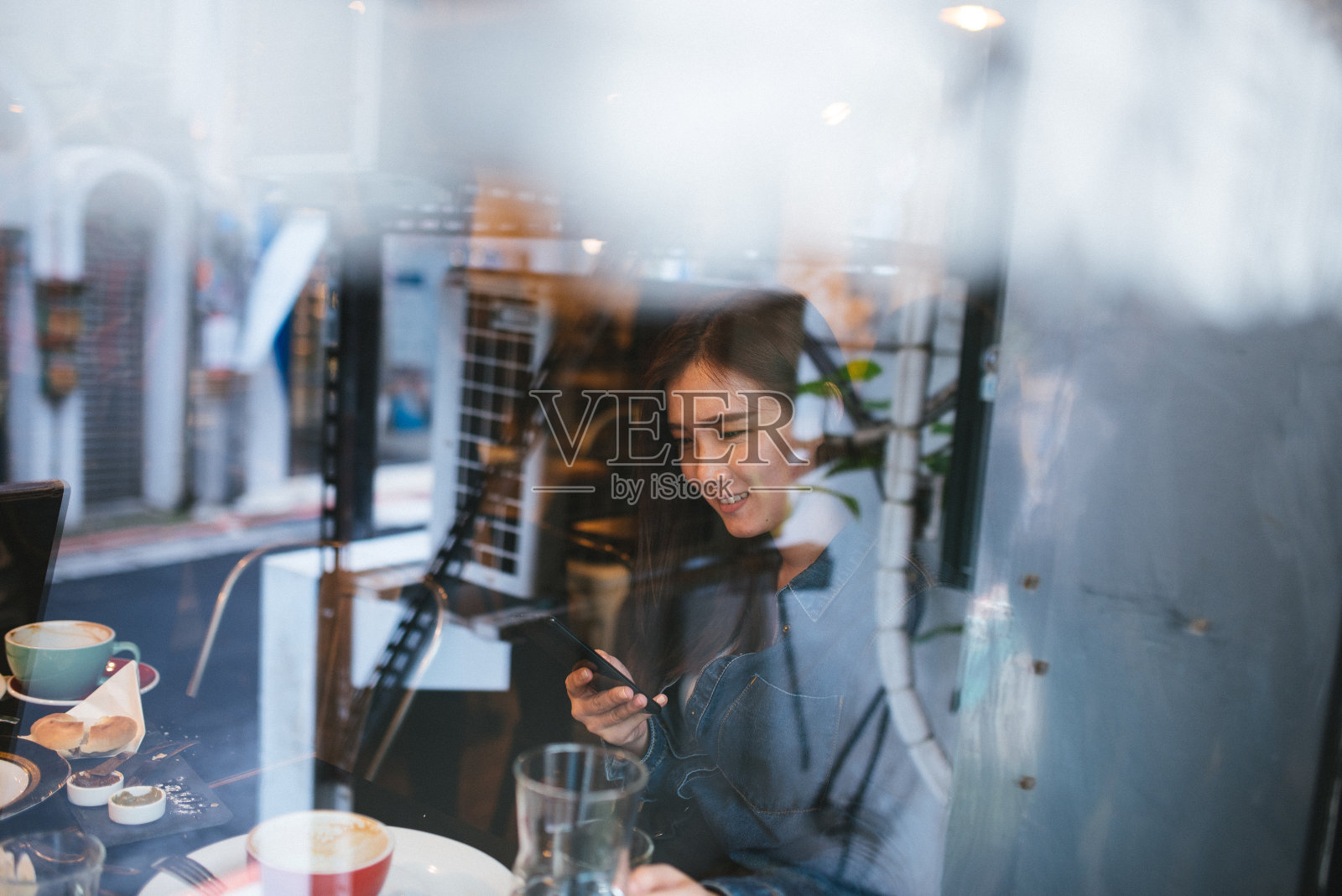 在咖啡厅里用手机的美女照片摄影图片