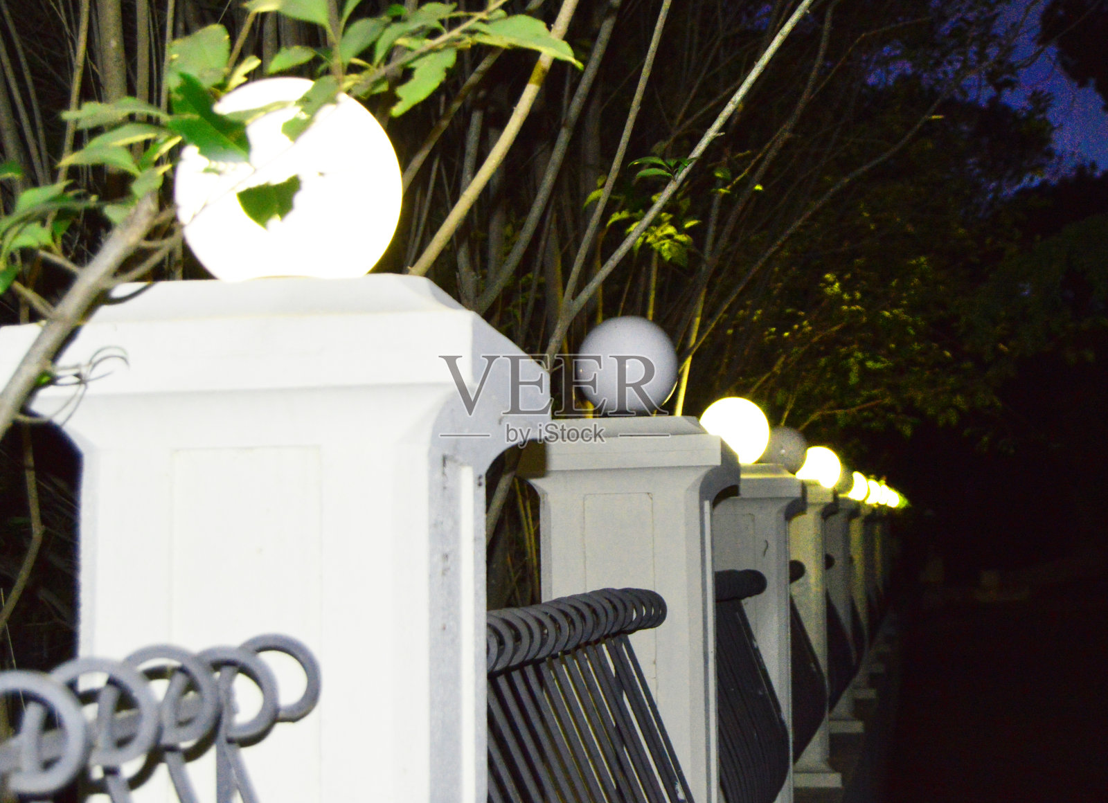 晚上，公园里的人行道上有古老的柱子和灯光照片摄影图片