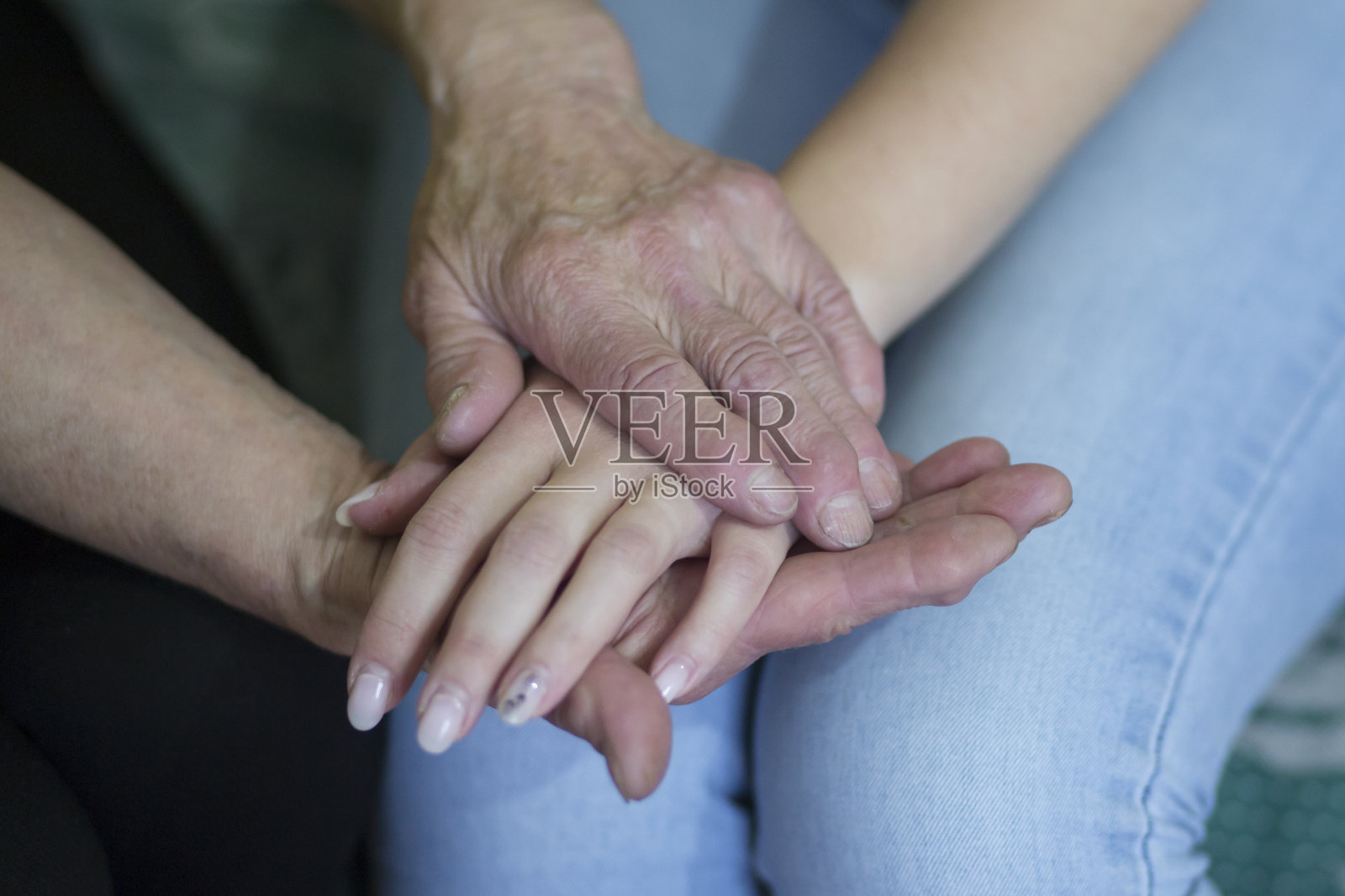 一个年轻女孩的手和一个老年妇女的手。照片摄影图片