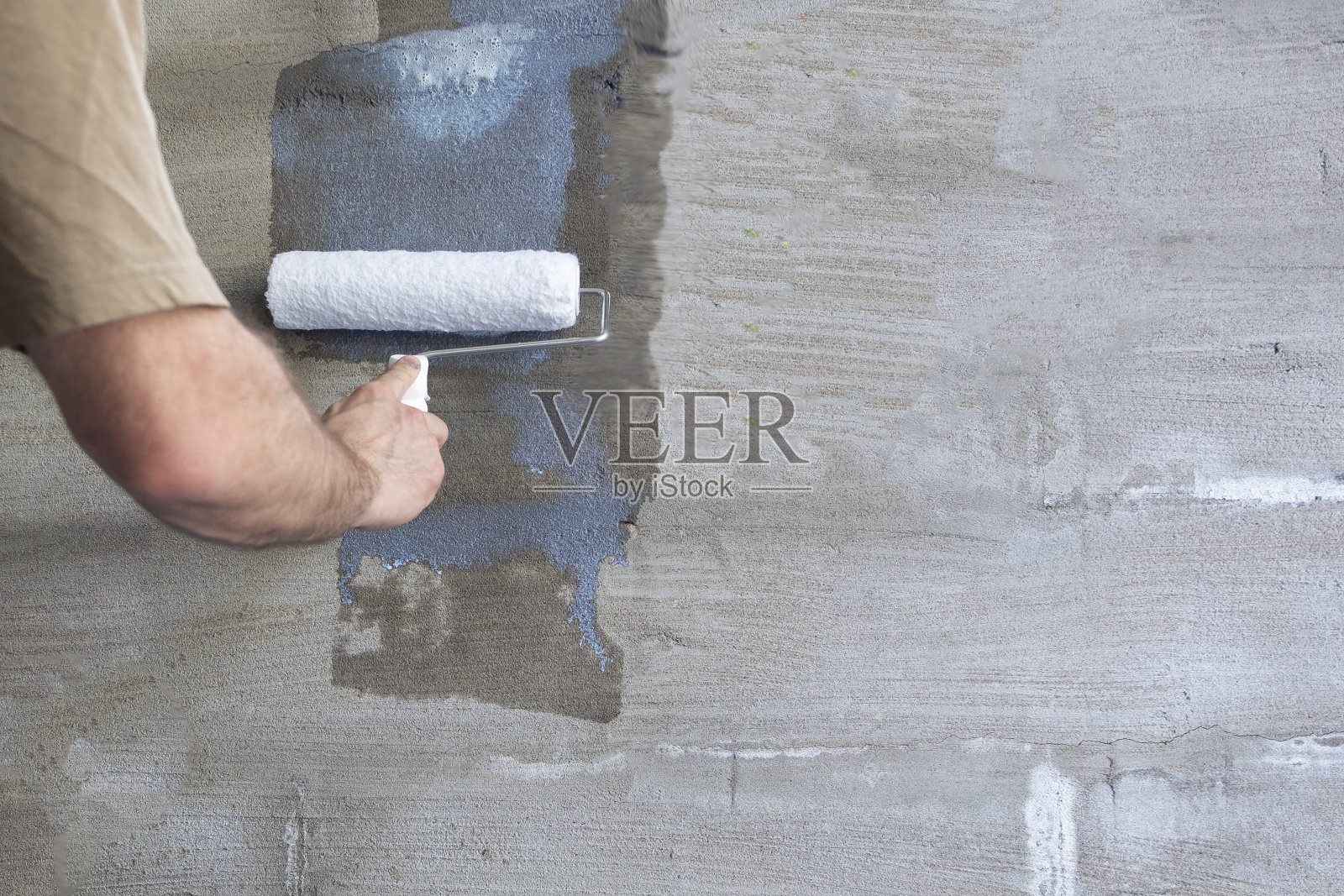建筑工程、抹灰和墙面底漆。建筑工的手和油漆滚筒。本空间照片摄影图片