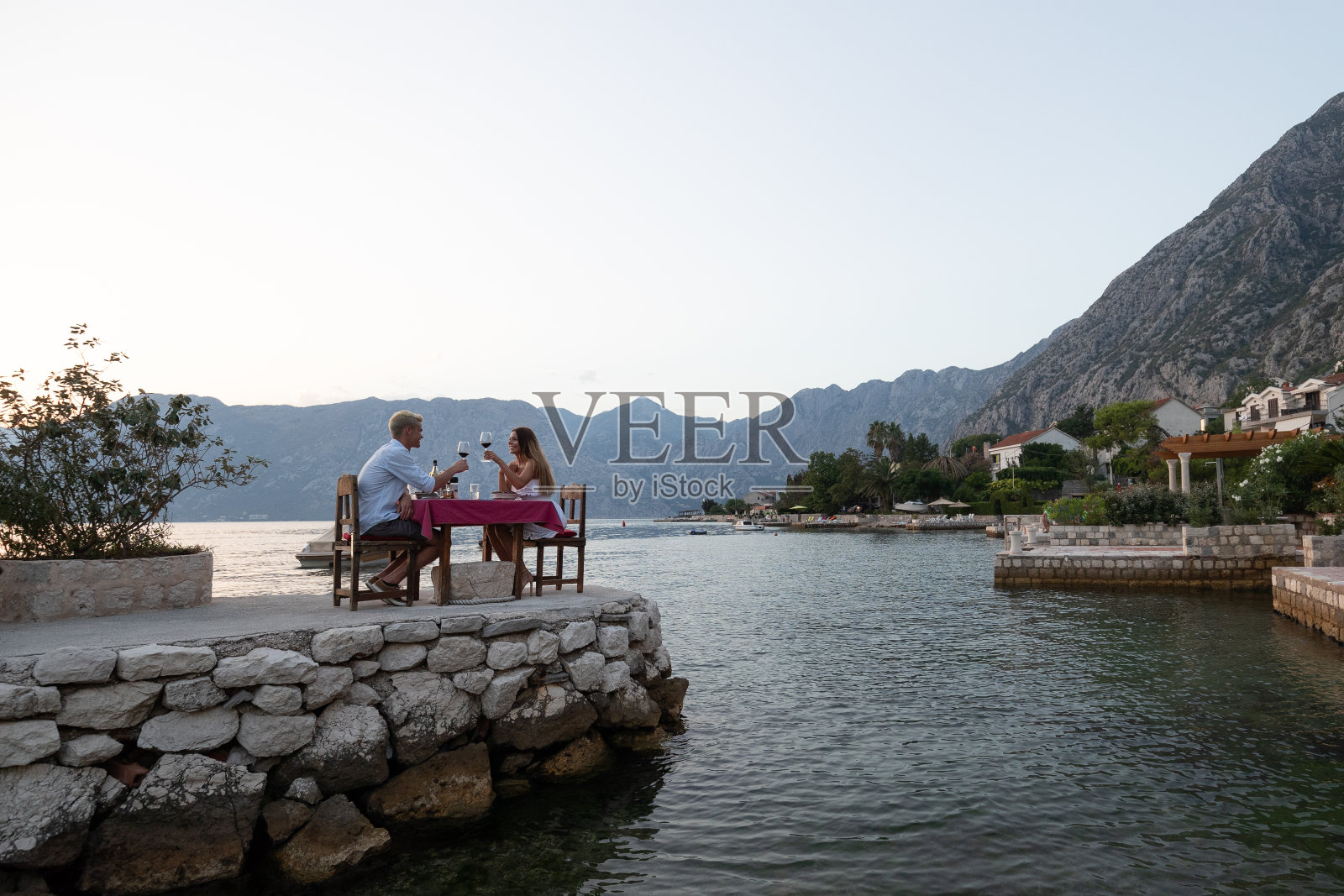 人、度假、爱情和浪漫的概念。年轻夫妇在海滩上享受浪漫晚餐。照片摄影图片