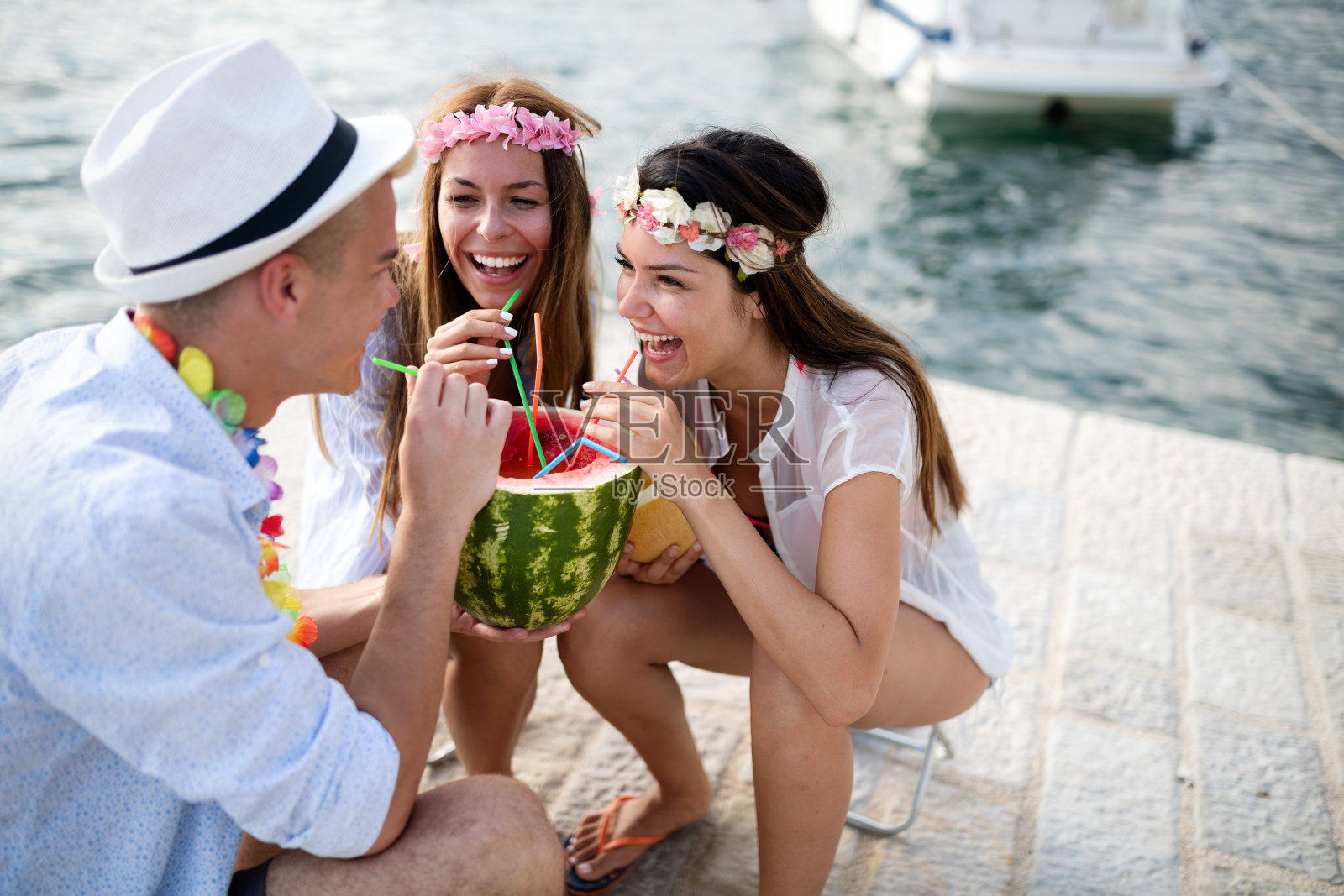 朋友们一起在海滩上玩，喝着鸡尾酒照片摄影图片