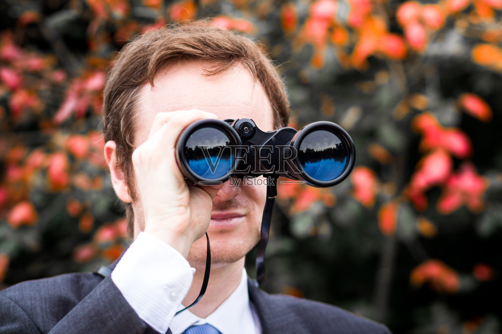 用双筒望远镜寻找机会的年轻企业家照片摄影图片