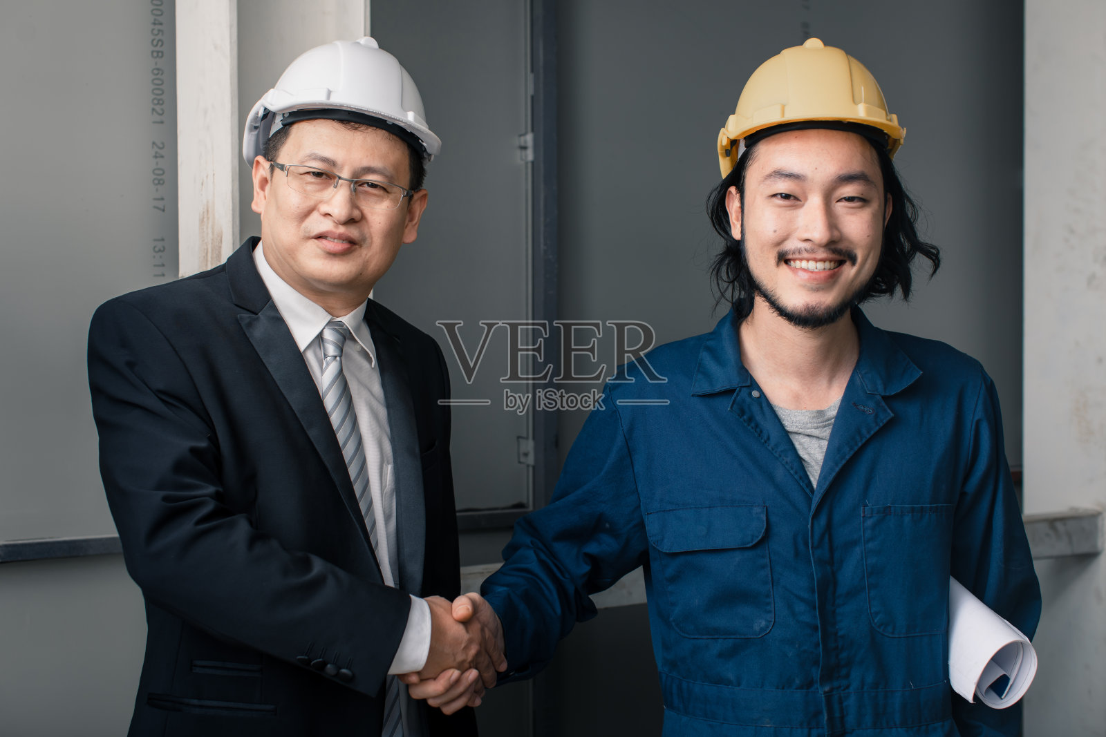 亚洲工程师看蓝图。照片摄影图片