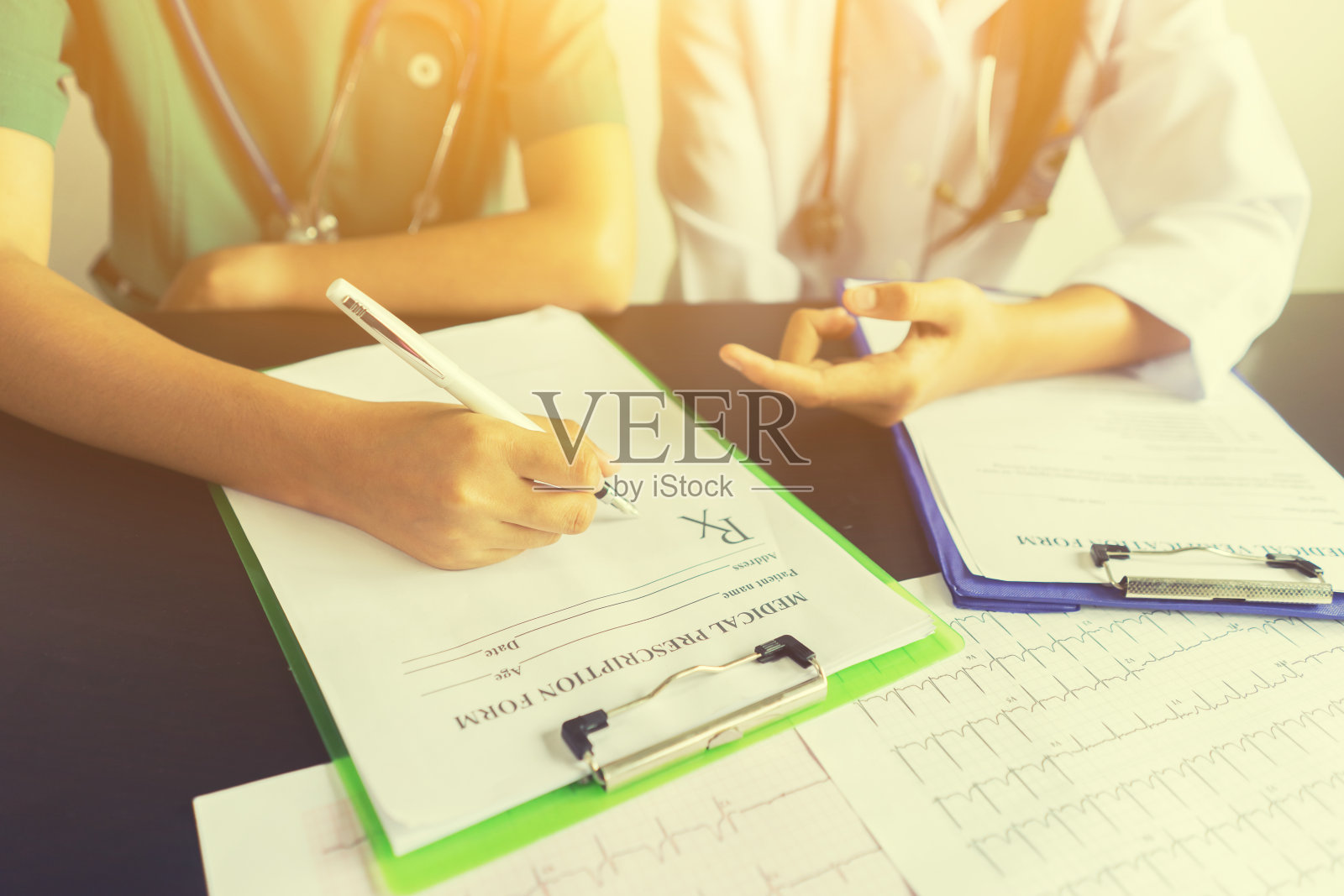 医务人员医生用听诊器和处方讨论病人的结果，作为专业的检查在现代医院走廊，复古的颜色照片摄影图片