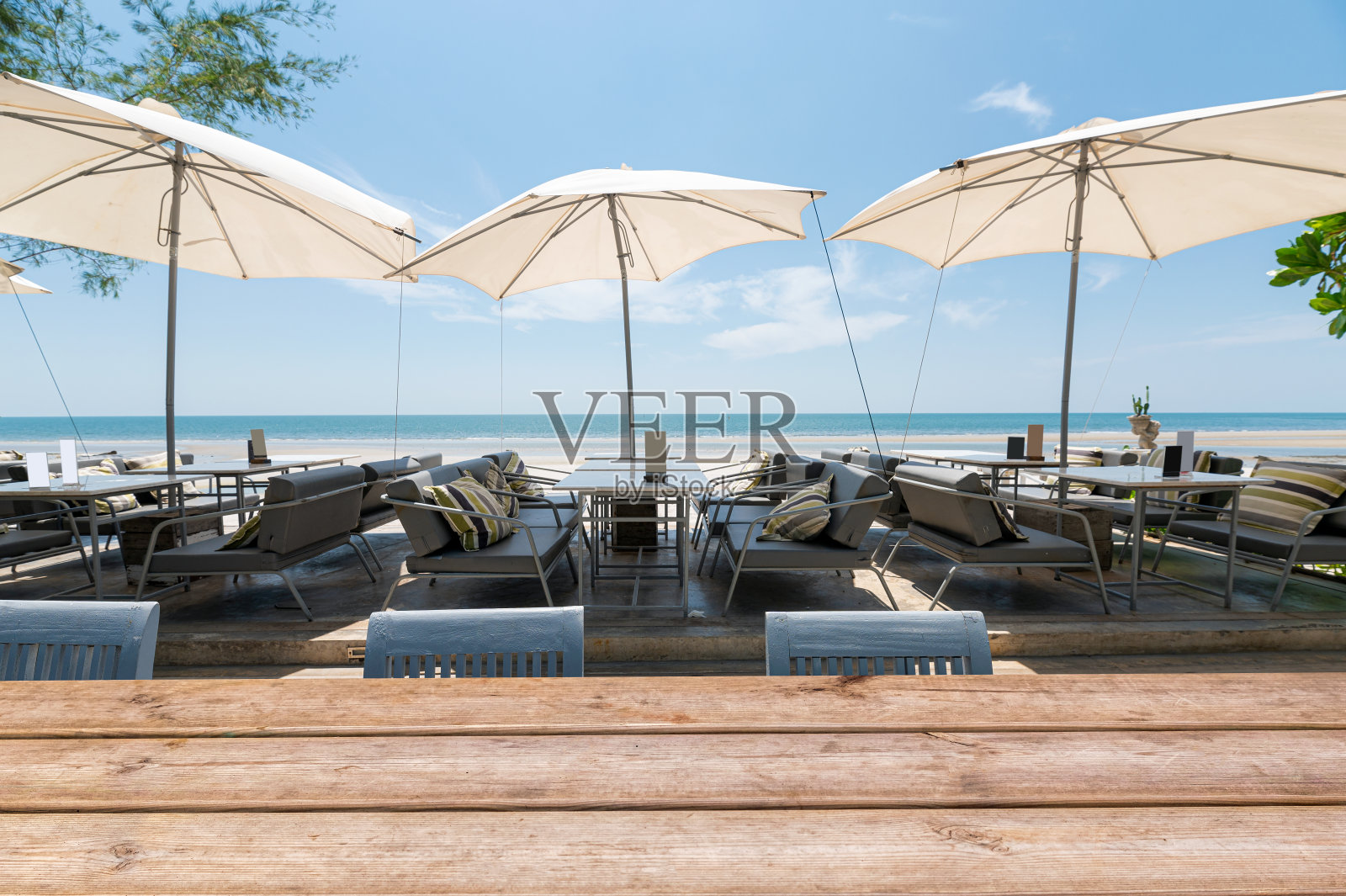 餐桌上的木质台面和沙滩上的雨伞照片摄影图片