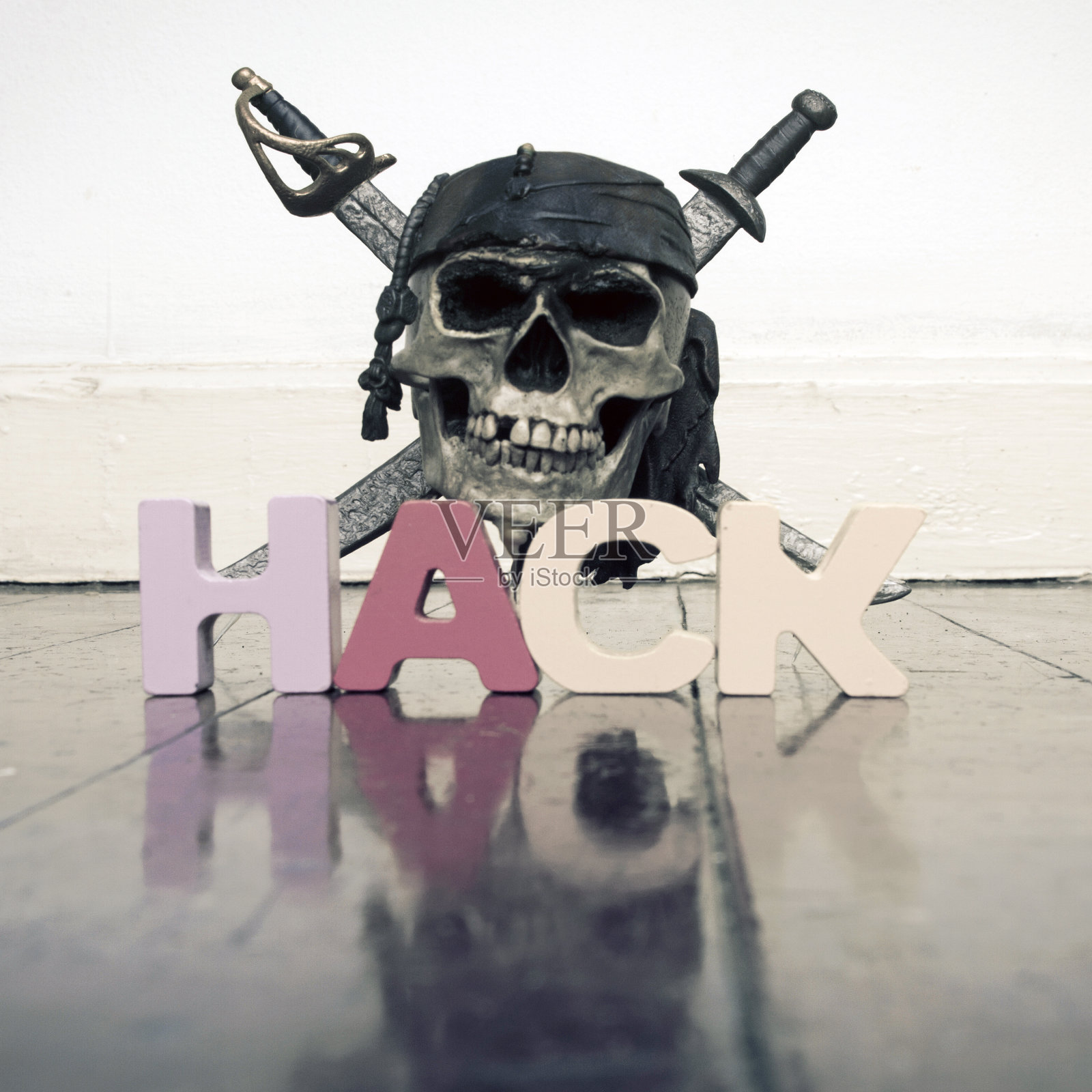 在旧木地板上放着骷髅头和交叉的骨头，上面写着“HACK”照片摄影图片