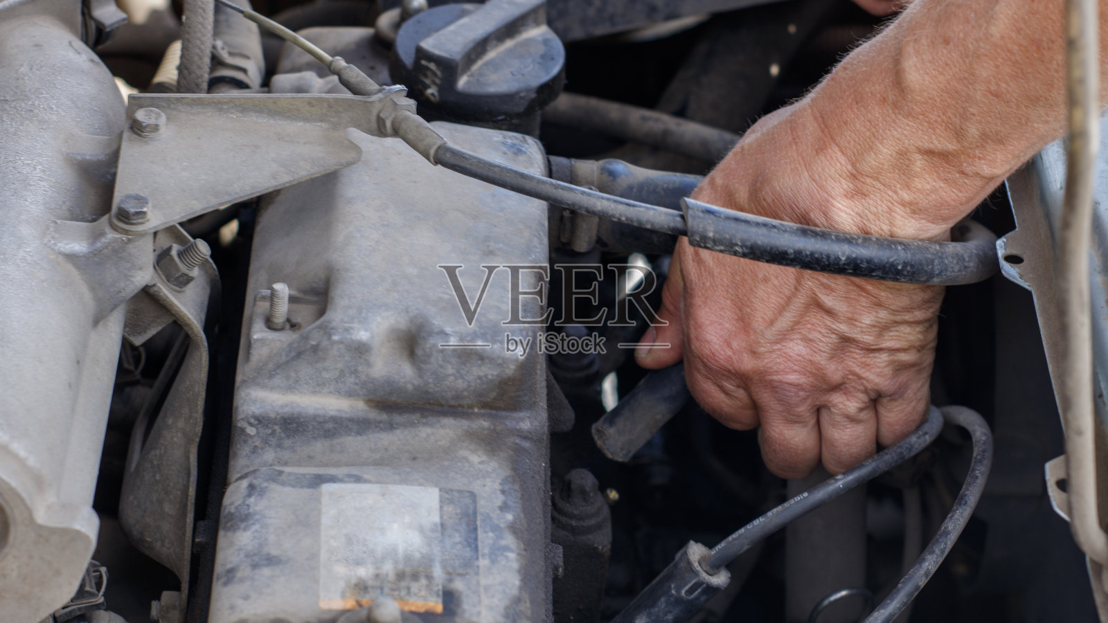 修理一辆旧车。主人的手握着软管照片摄影图片
