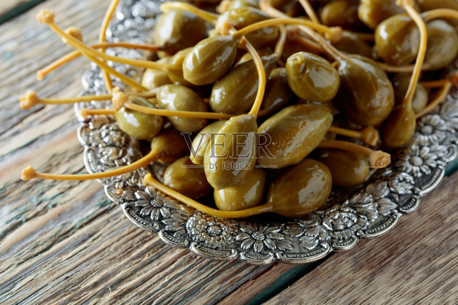 金属盘里的酸豆。照片摄影图片