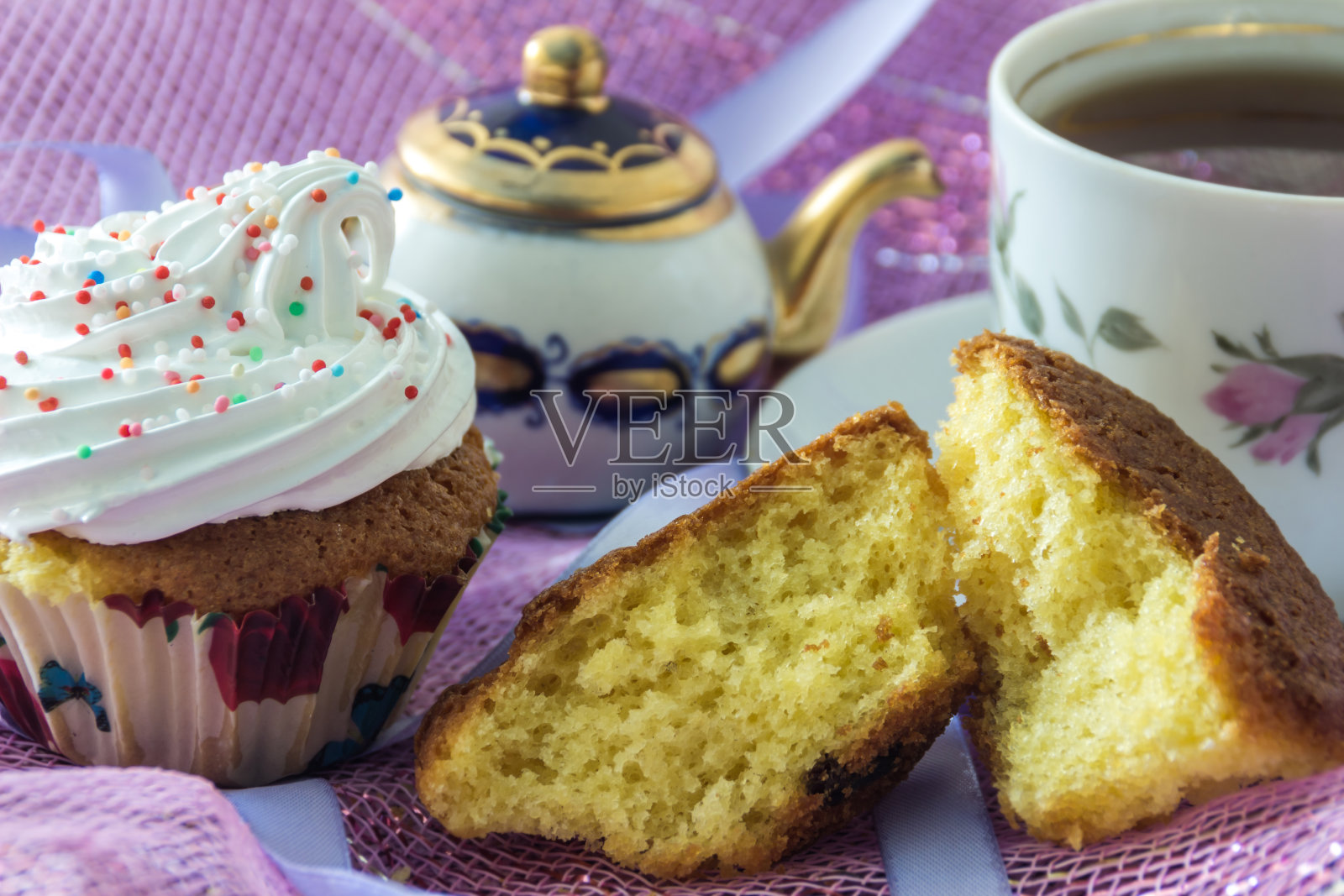 分开的饼干松饼和松饼，装饰发泡蛋白奶油，在茶和茶壶的背景杯照片摄影图片