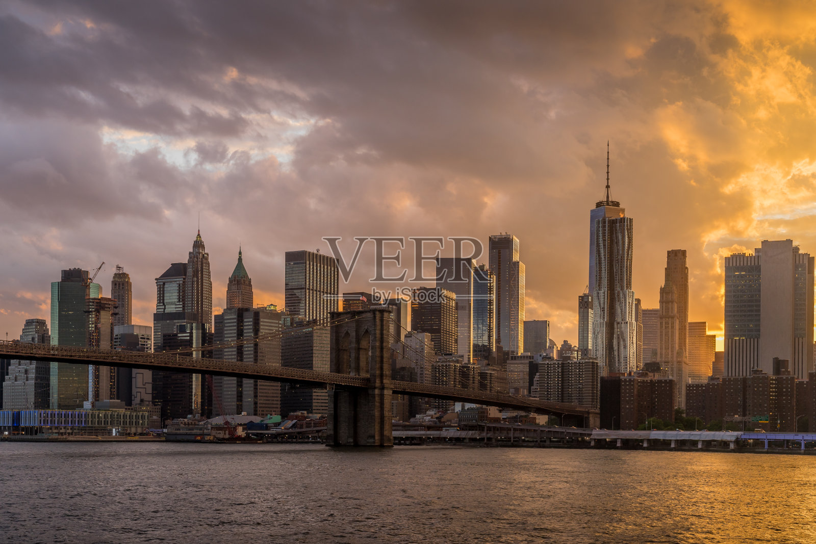 日落的布鲁克林大桥与下曼哈顿天际线的背景在东河，纽约市照片摄影图片