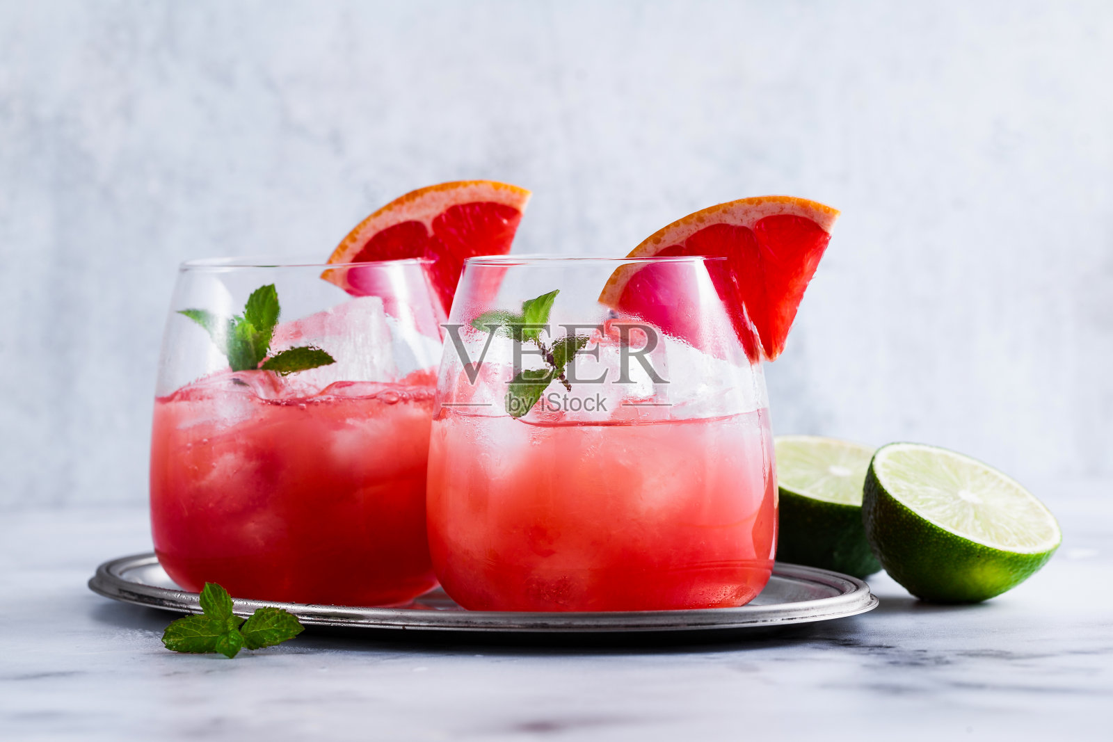 柚子和冰玻璃杯组成的帕洛玛酒，放在大理石桌子上。新鲜的饮料与酸橙汁照片摄影图片