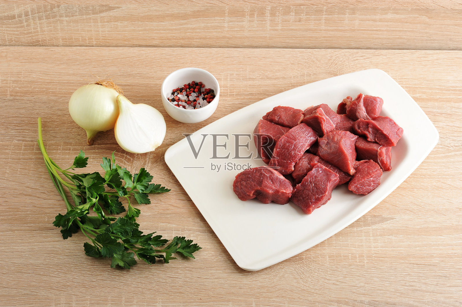 煮肉末用的餐具。白色托盘上的牛肉片。照片摄影图片