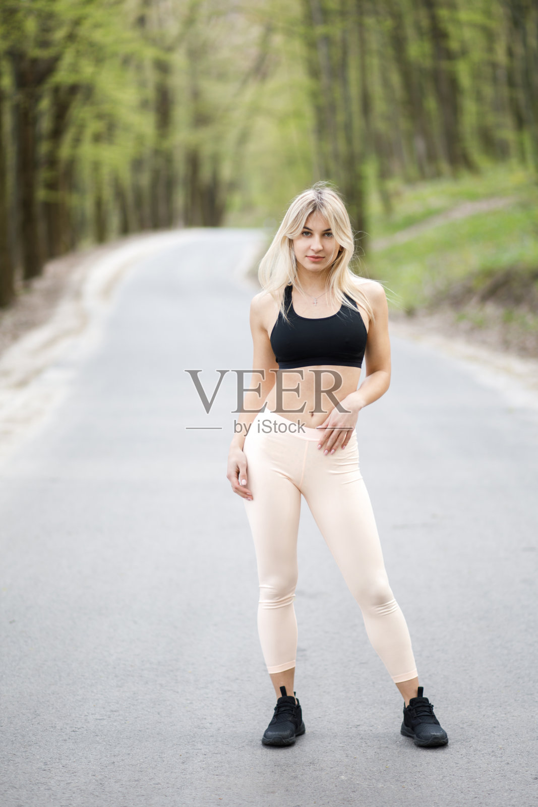 一个年轻、富有同情心的金发女人正积极地花时间在户外。那女孩穿着运动服。户外运动。对身体的健康和益处照片摄影图片