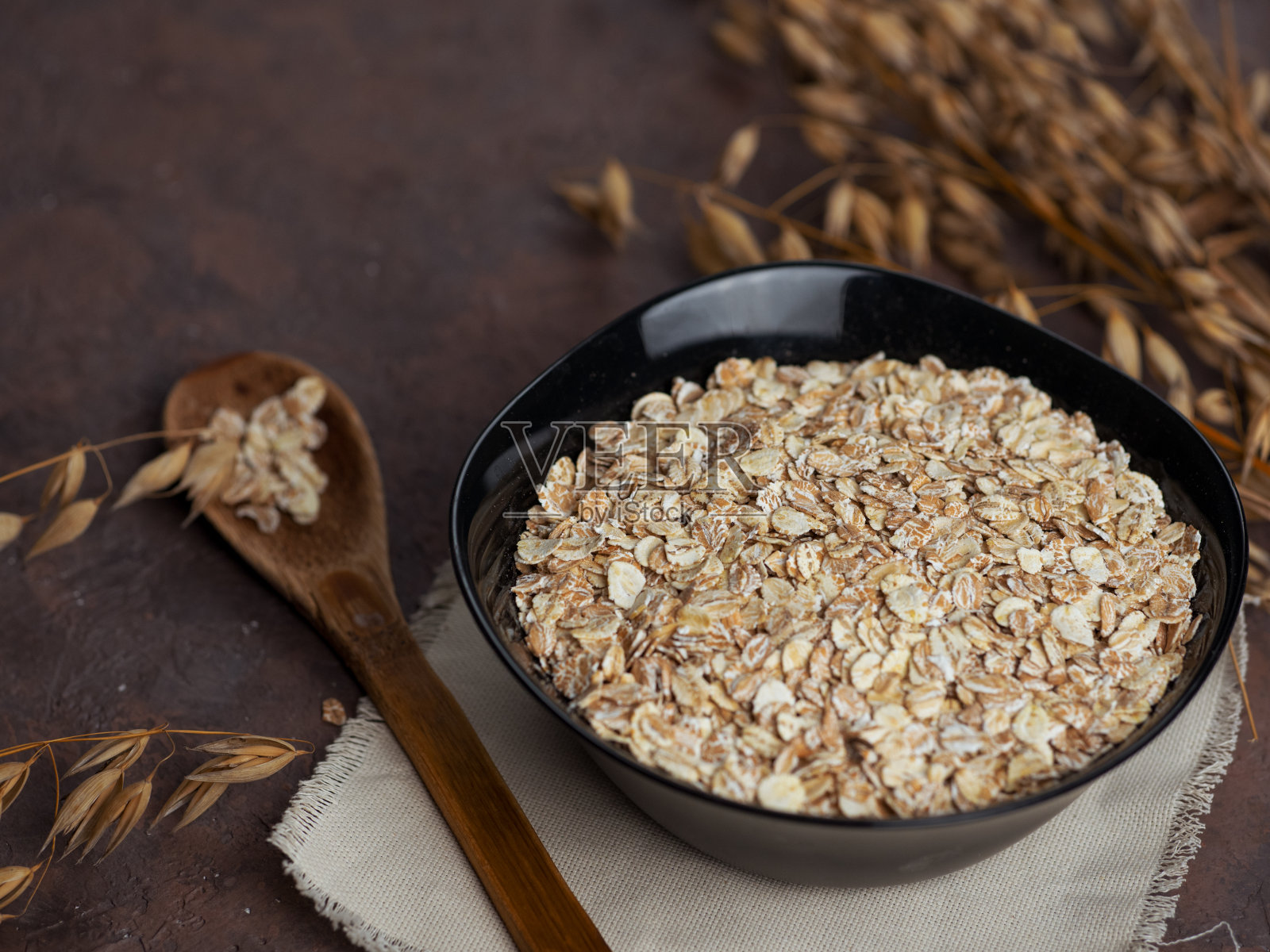 燕麦片和燕麦穗。燕麦片放在桌子上的盘子里。健康的早餐照片摄影图片