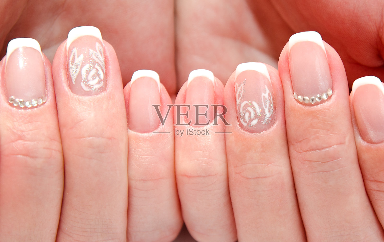 女人的指甲与美丽的法国美甲时尚设计与宝石照片摄影图片