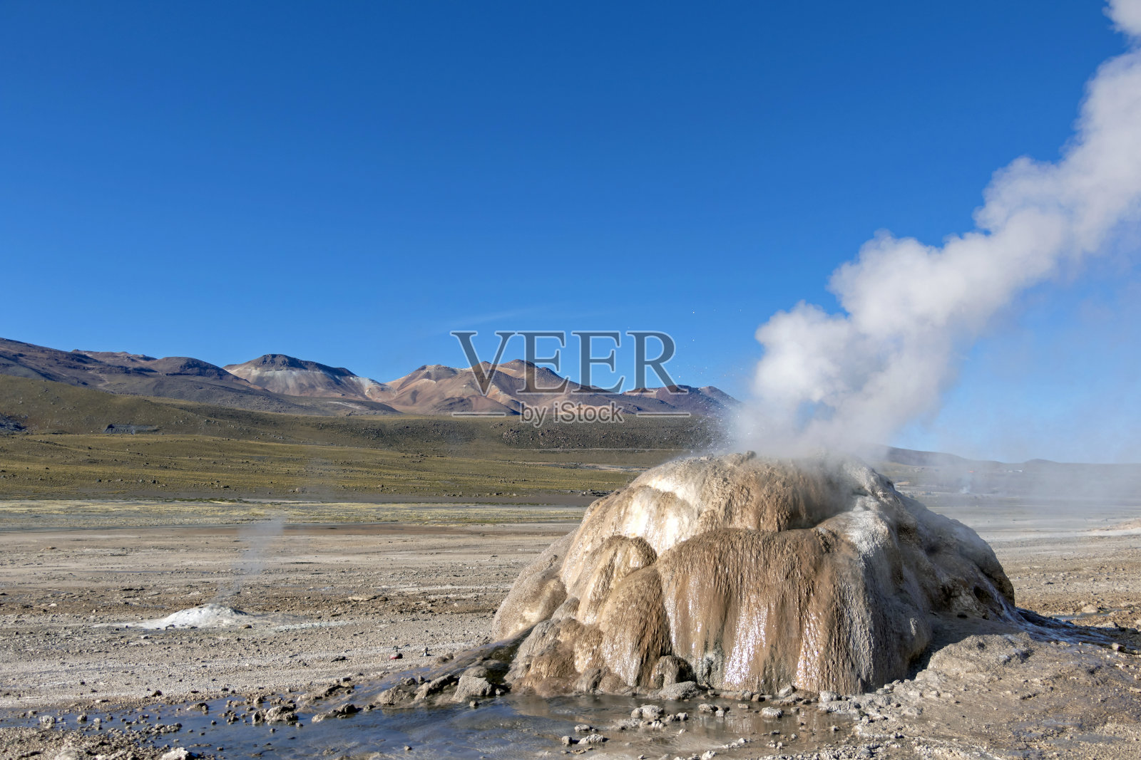 在智利阿塔卡马沙漠的埃尔塔提奥间歇泉中，在清晨日出时喷发的热间歇泉蒸汽照片摄影图片