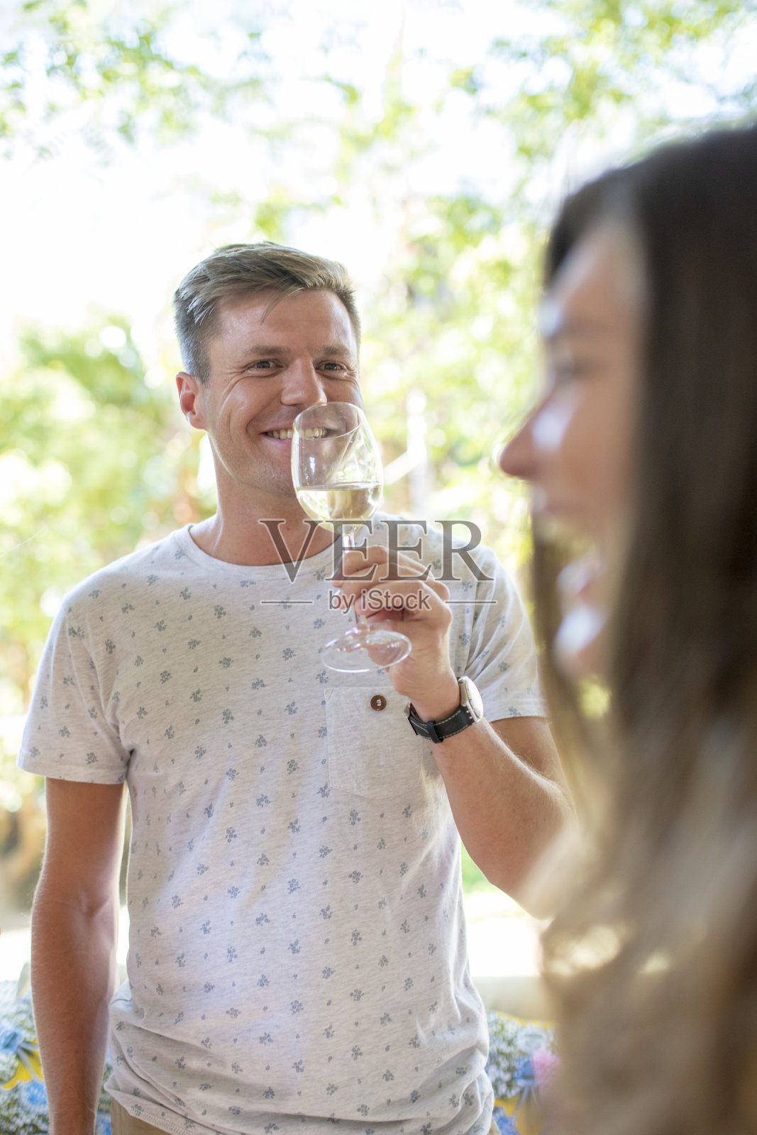 在花园派对上喝白葡萄酒的帅哥照片摄影图片