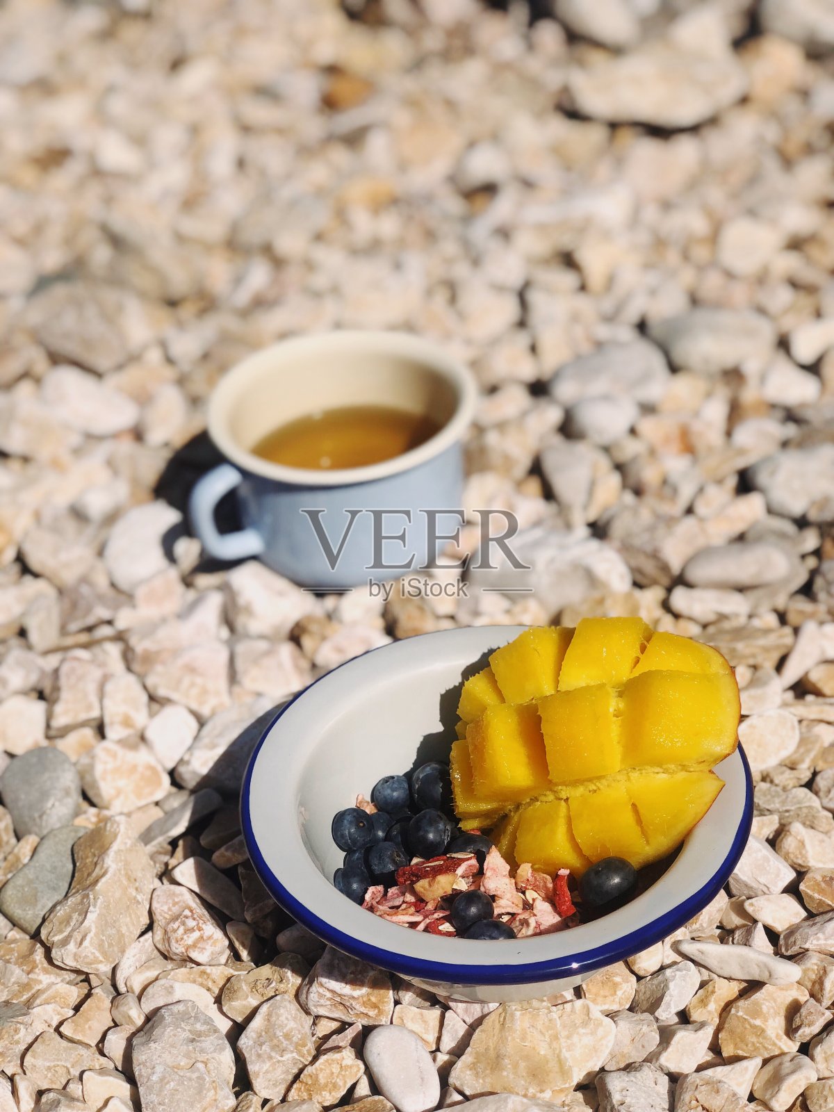 燕麦碗、蓝莓、芒果和一杯茶照片摄影图片