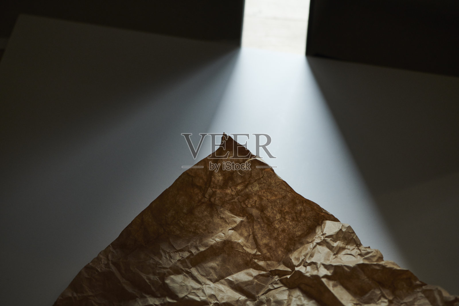白色桌子上的皱巴巴的牛皮纸照片摄影图片