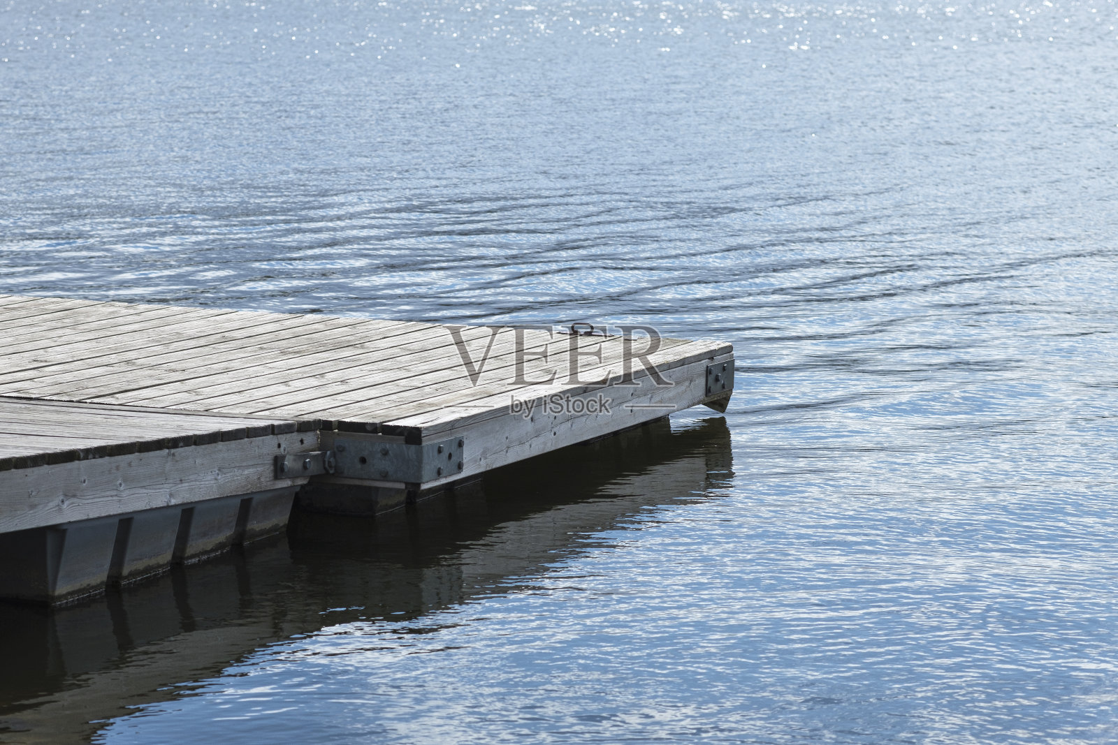 湖上的码头。木桥在春天的时候与蓝色的湖。有码头的钓鱼湖。照片摄影图片