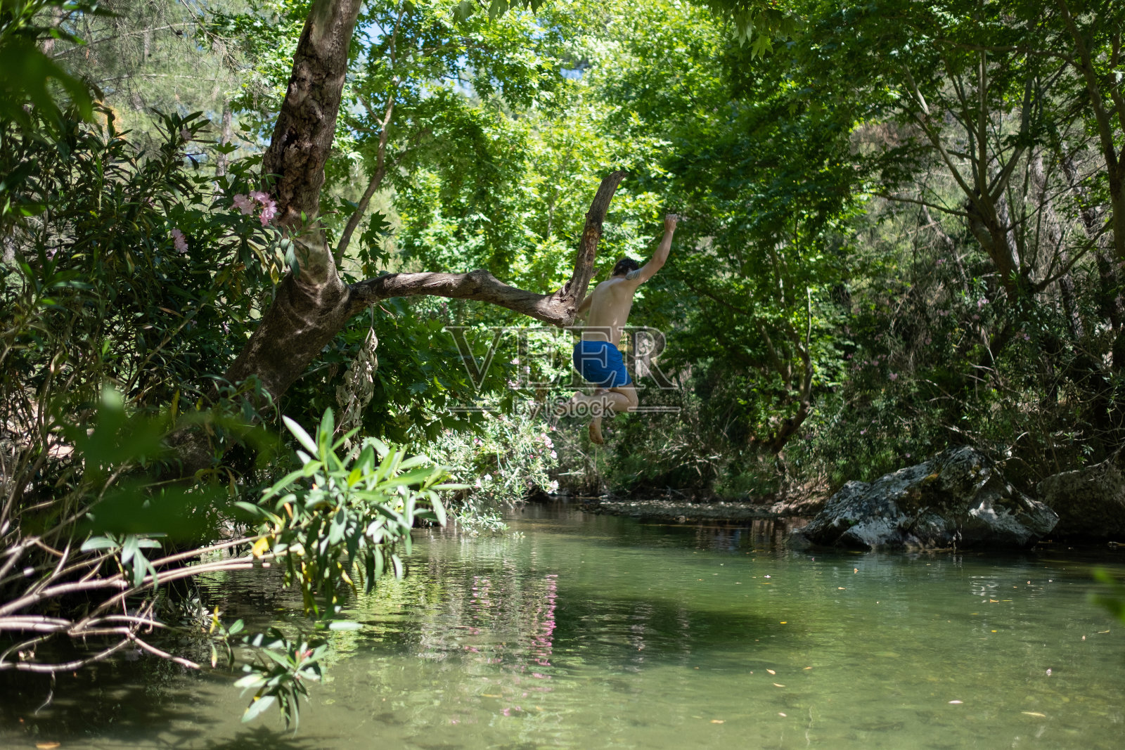 跳入河中的年轻人照片摄影图片
