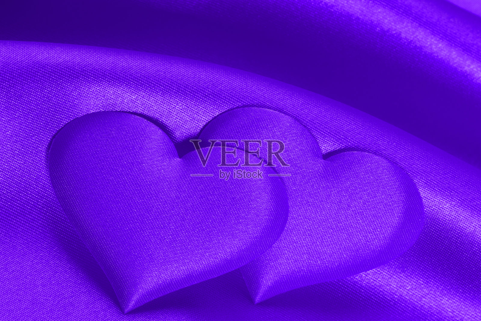 浪漫的背景(紫色绸缎上的一对紫心)照片摄影图片