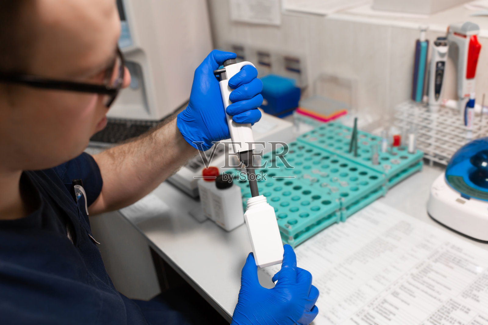 实验室助理使用微管分析血液样本照片摄影图片