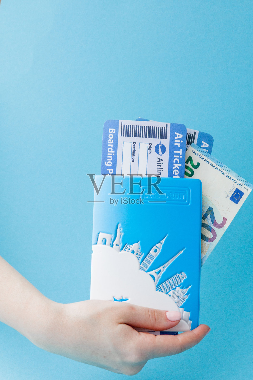 护照、欧元和机票都是女人拿的，背景是蓝色。旅行概念，复制空间照片摄影图片