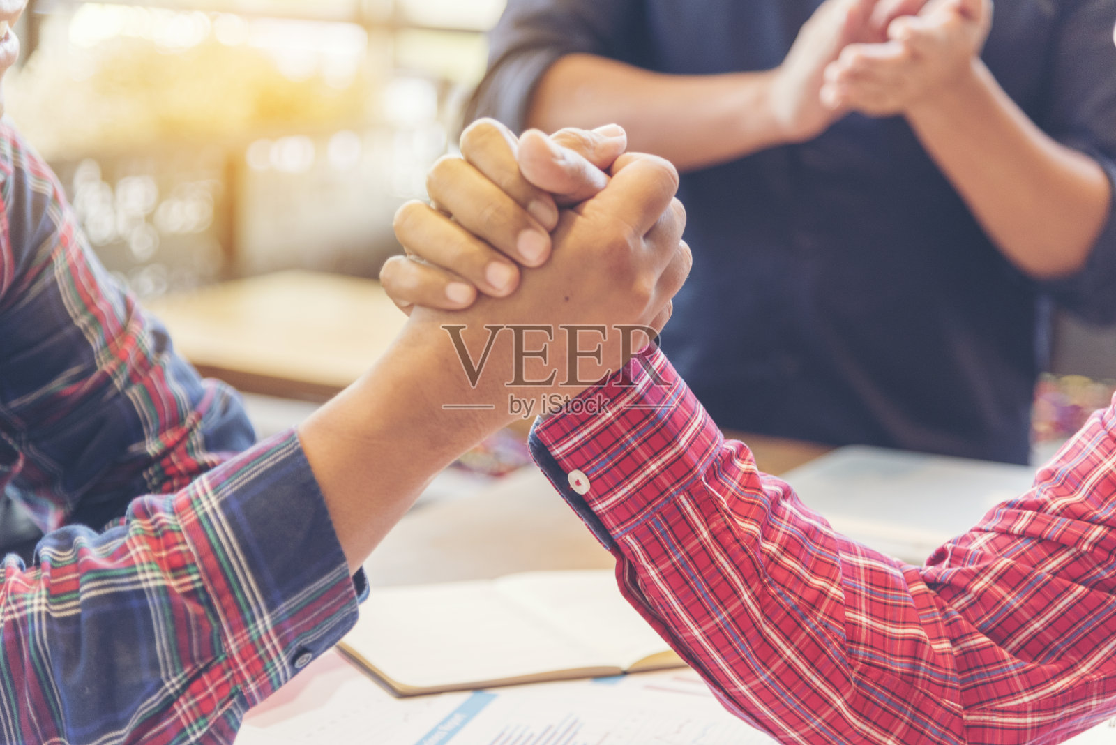 完成一笔交易后，团队商业伙伴互相碰拳。办公室里成功的团队合作伙伴关系。商人携手共进。行业经营理念。照片摄影图片