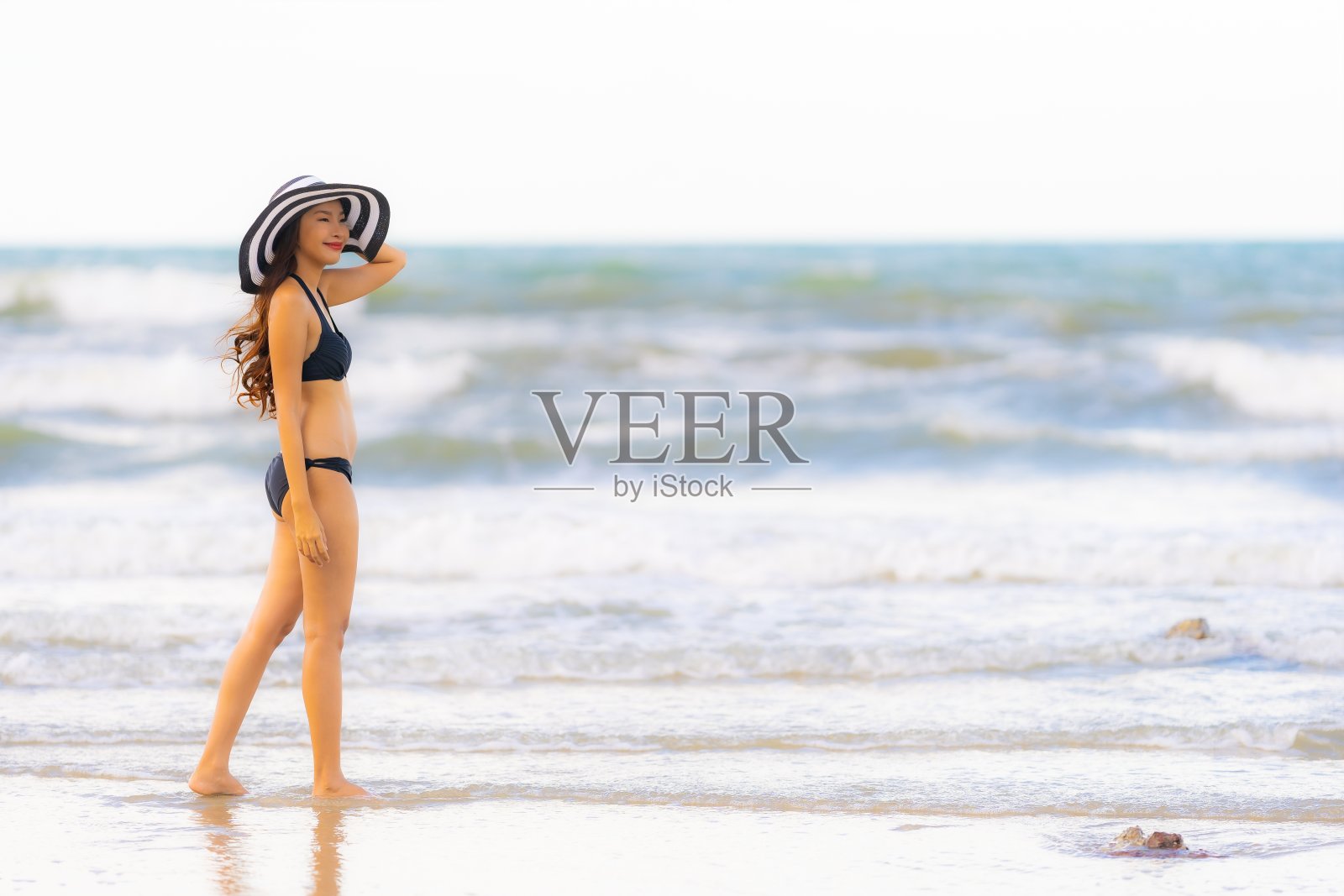 肖像美丽的年轻亚洲女子穿着比基尼在海滩上大海大海照片摄影图片