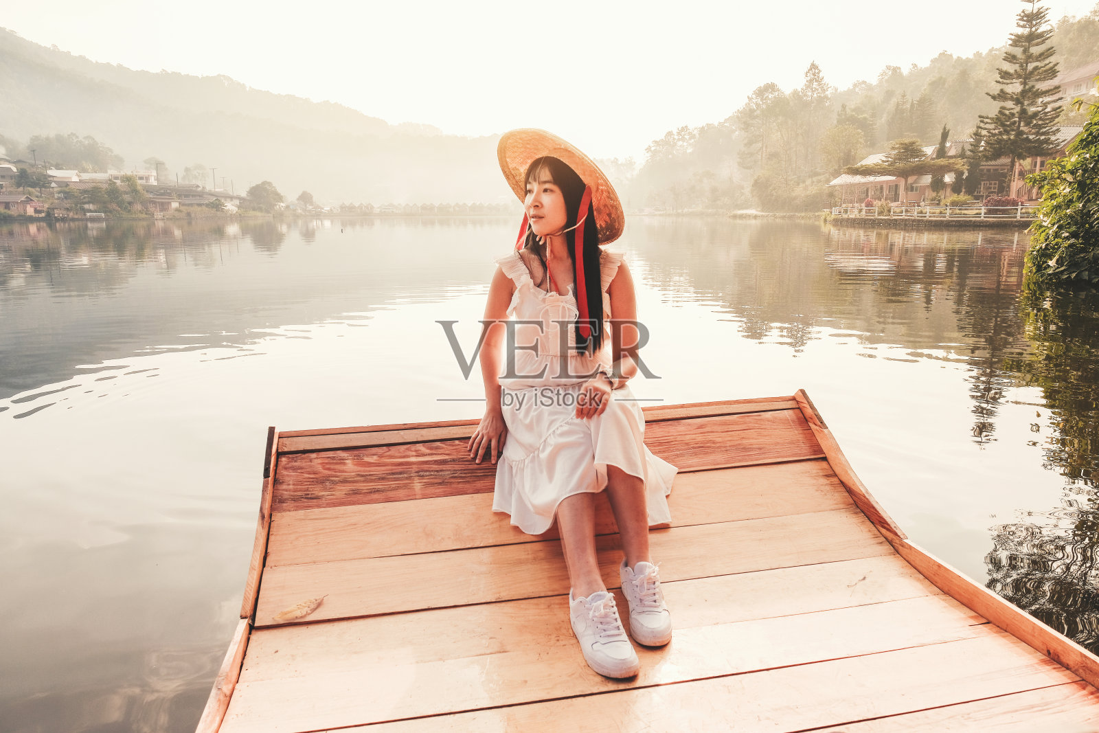 在晨光和雾中，湖上有中国风格的小船。照片摄影图片